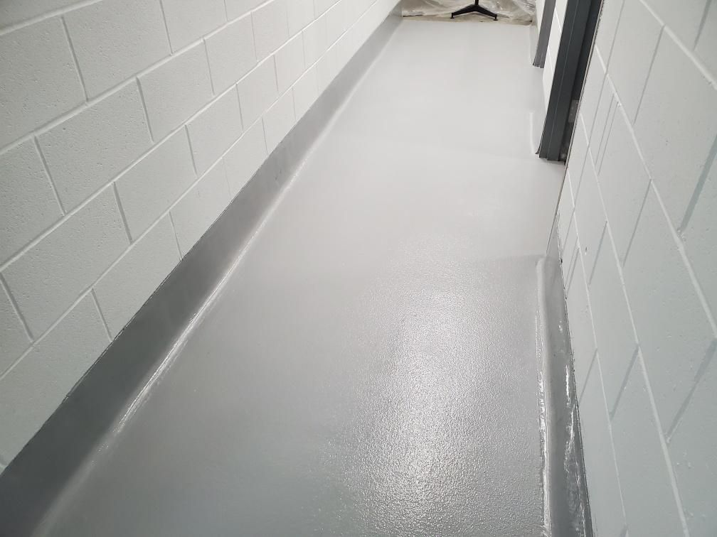 Seamless gray epoxy corridor with coved base in food and beverage production facility