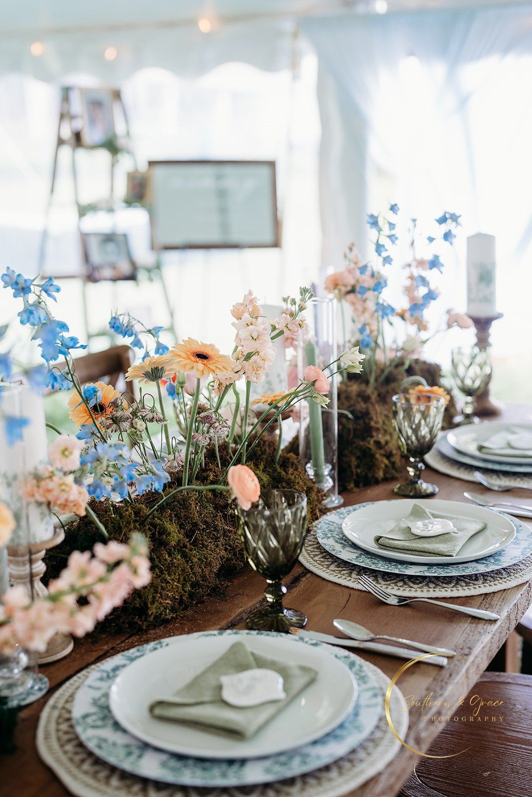 Intimate reception table with moss runner and pastel floral centerpiece