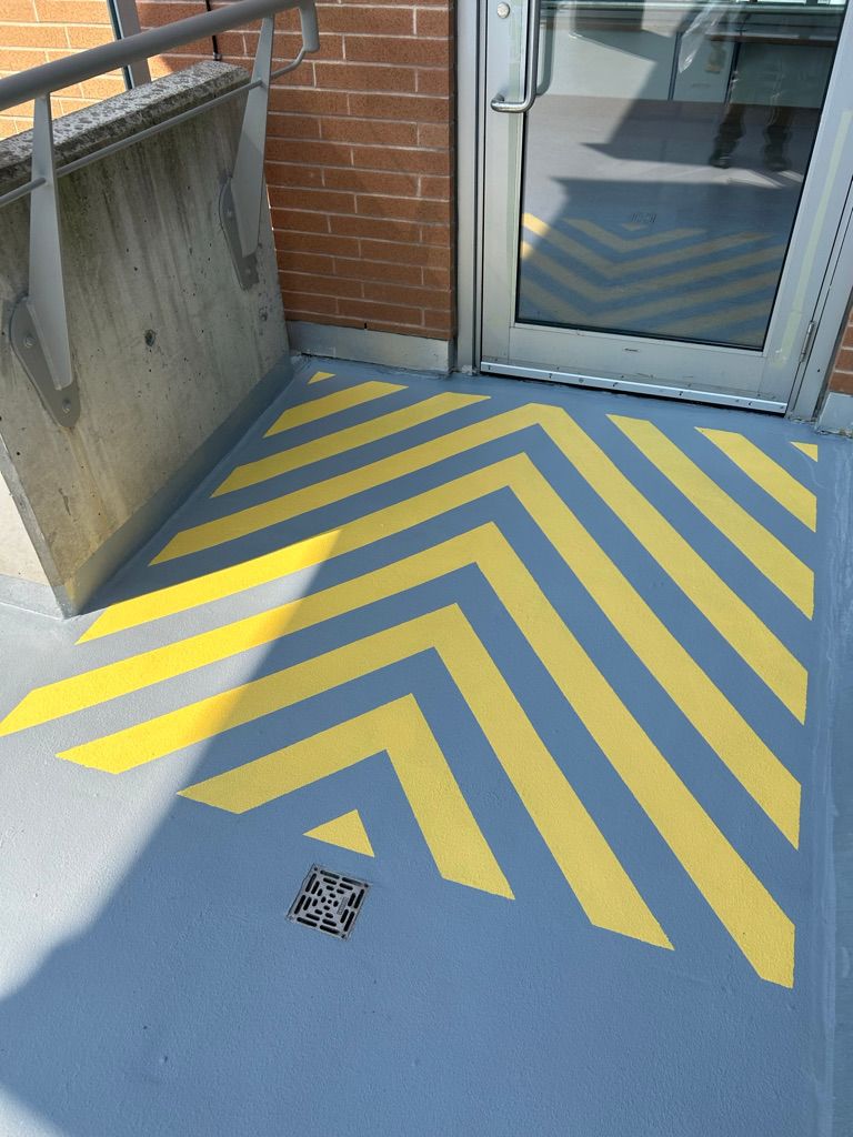 Outdoor corridor with light blue polymer coating and yellow safety chevrons