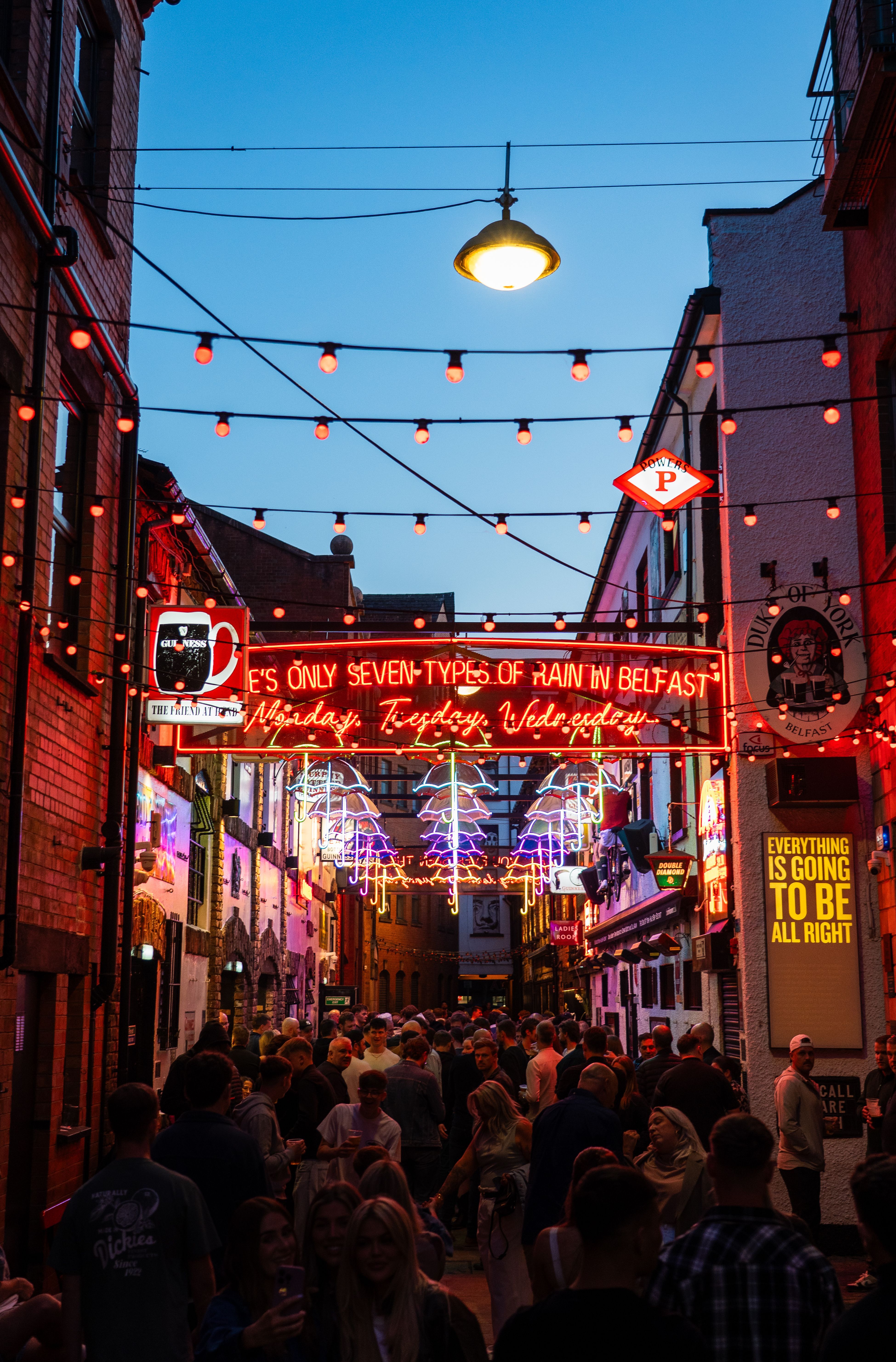 Belfast alleyway at night with neon signs and red lights
