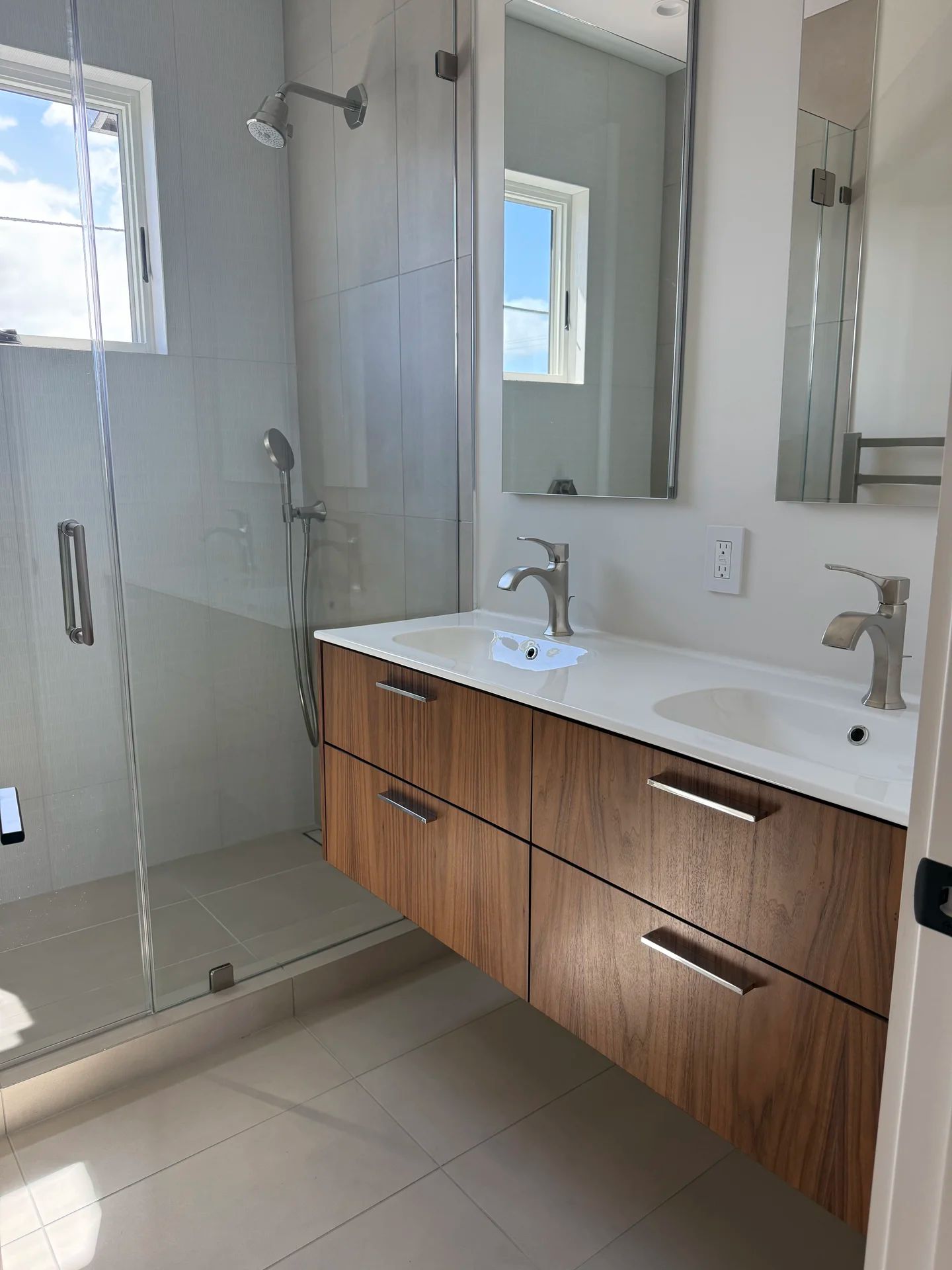 Double vanity bathroom with glass shower — luxury bath installation by PGKB