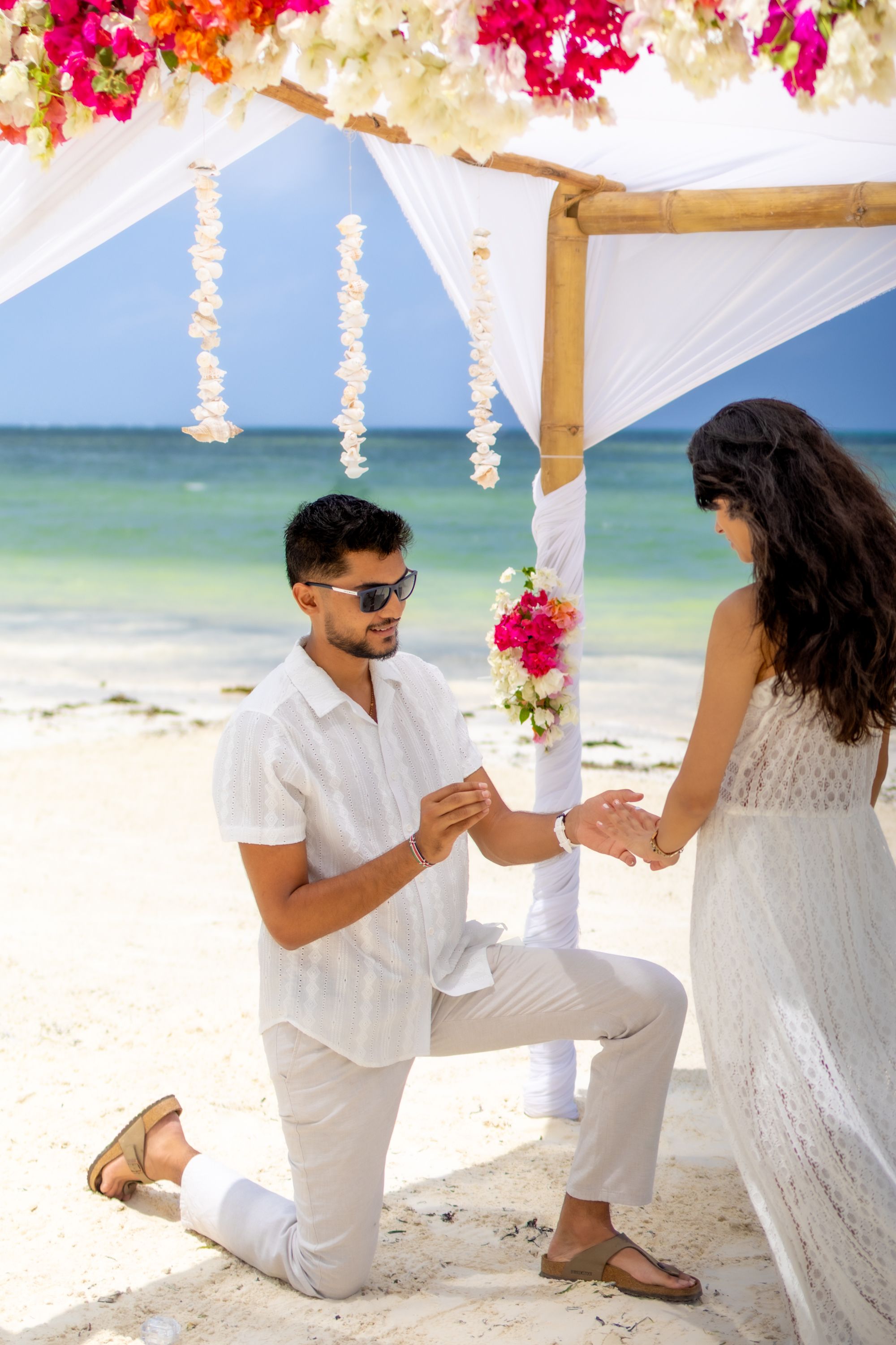 Surprise beach proposal under flower canopy in Zanzibar