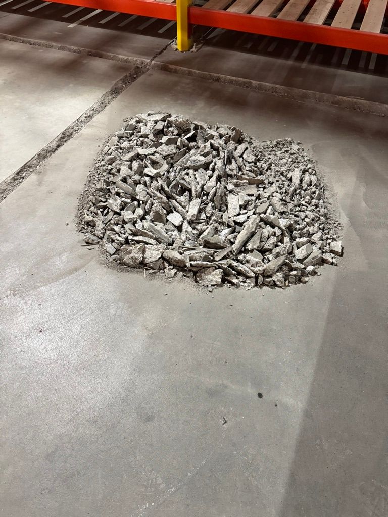 Pile of broken and removed concrete debris during warehouse floor concrete repair and preparation