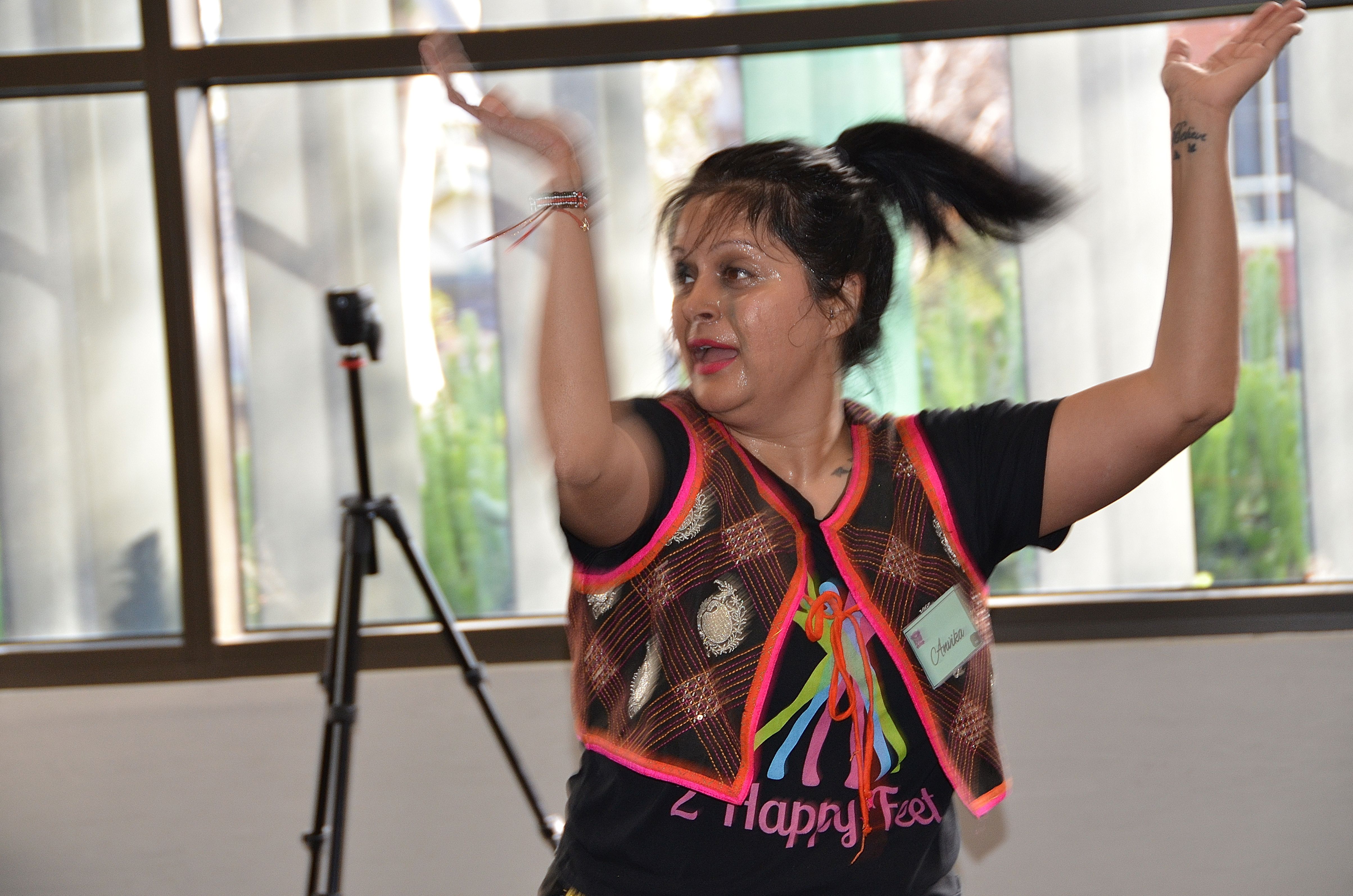 Woman dancing with arms raised at E-Girl Empowerment fitness and dance session