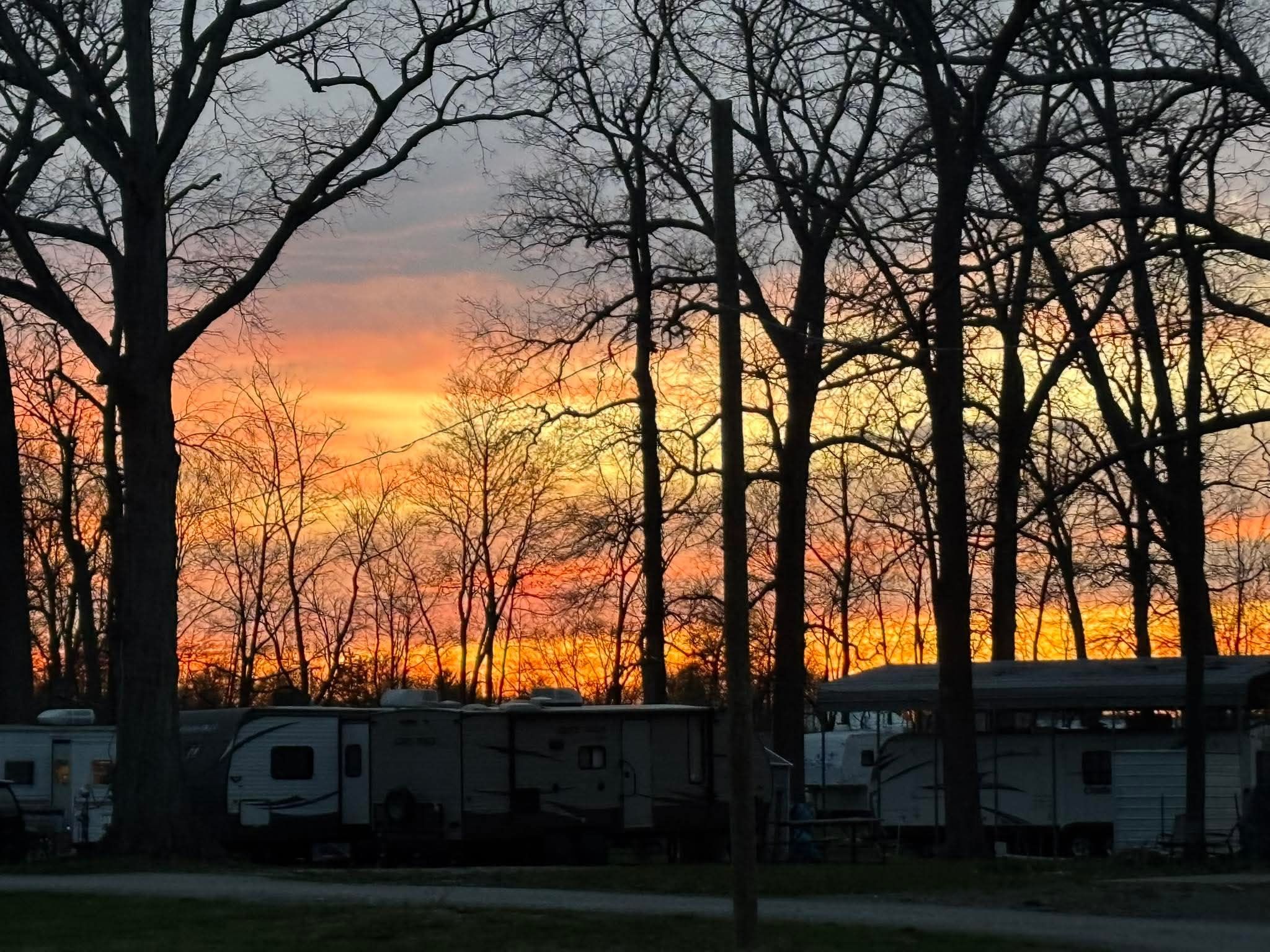 Beautiful sunset over Welcome Woods RV Campground with trees and trailers