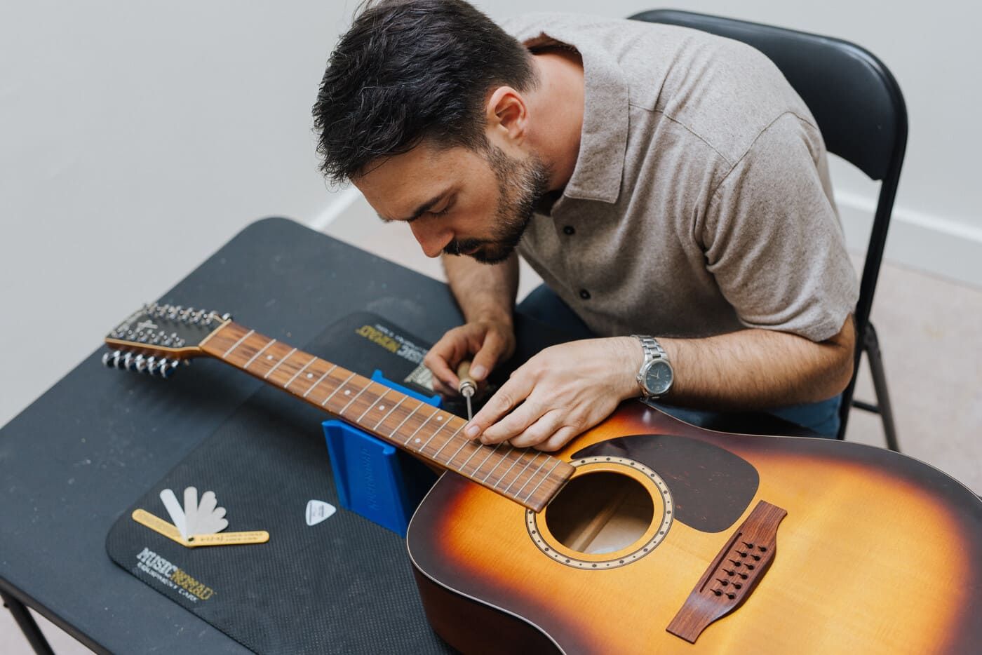 Tyler working on a guitar — hands-on expertise that informs every consultation