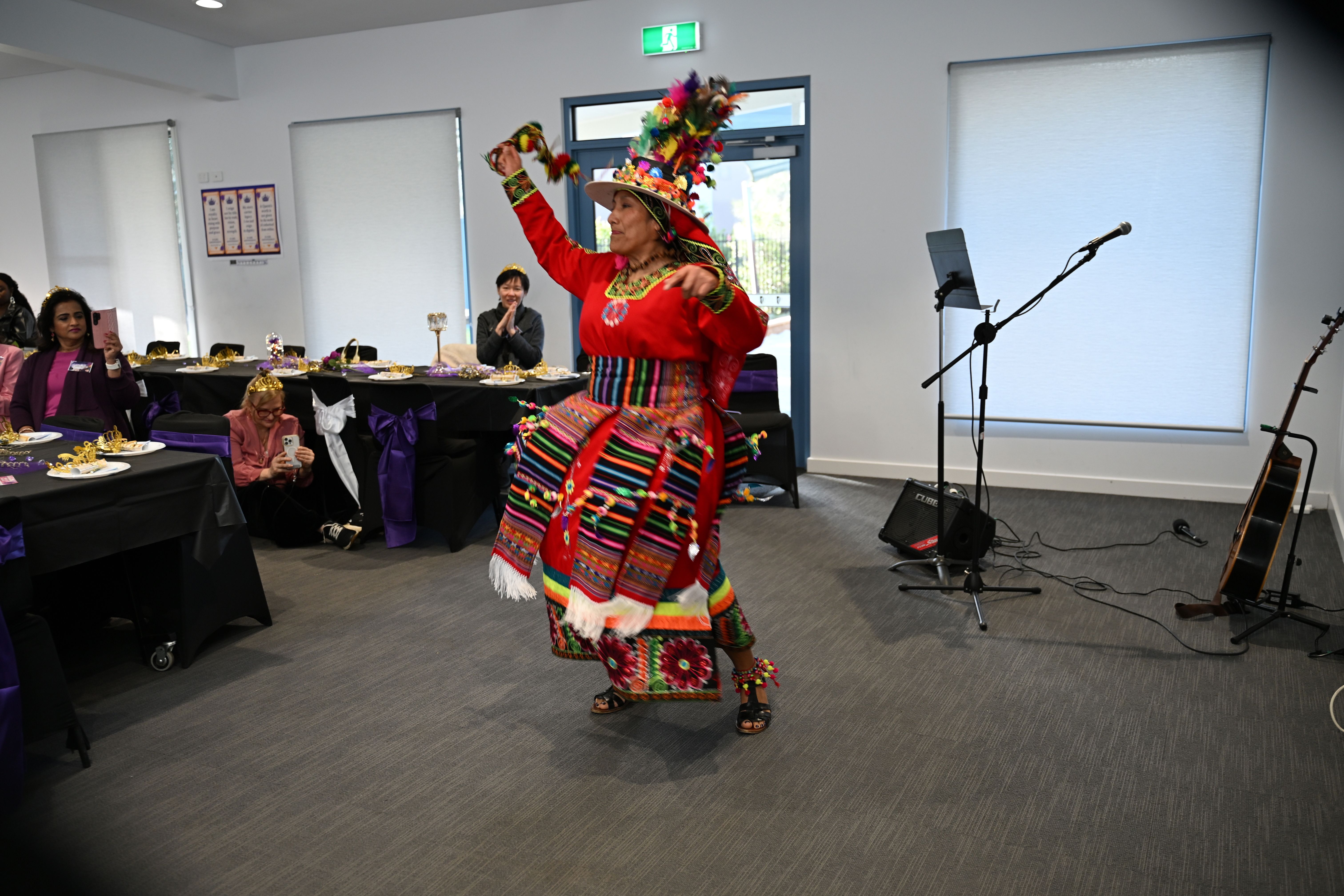 Woman in vibrant traditional outfit performing a cultural dance at E-Girl Empowerment event
