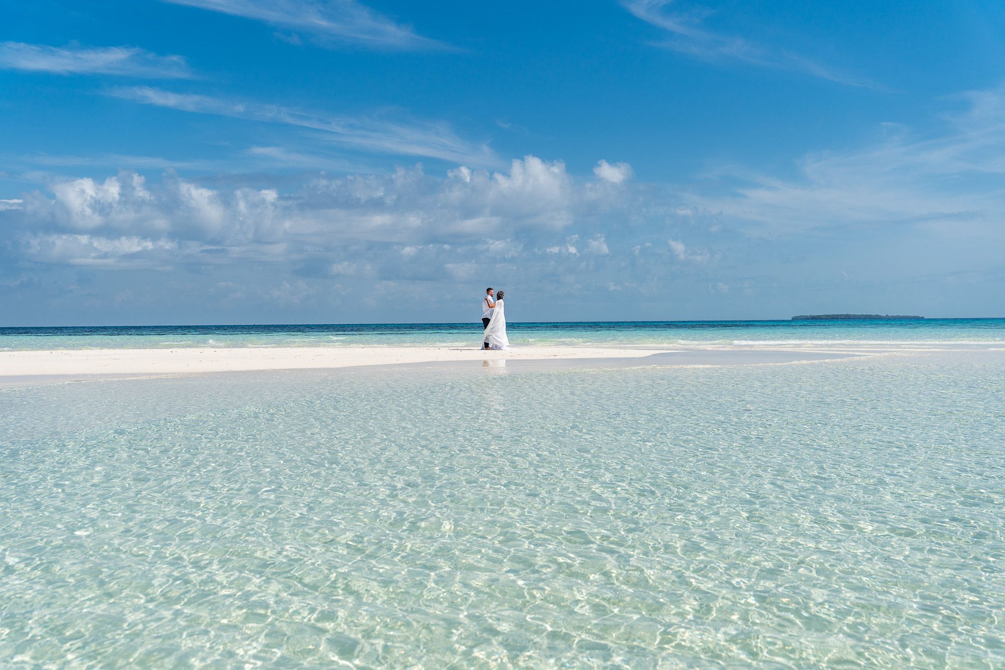 Couple on white sand with veil flowing in the wind - sandbank Zanzibar