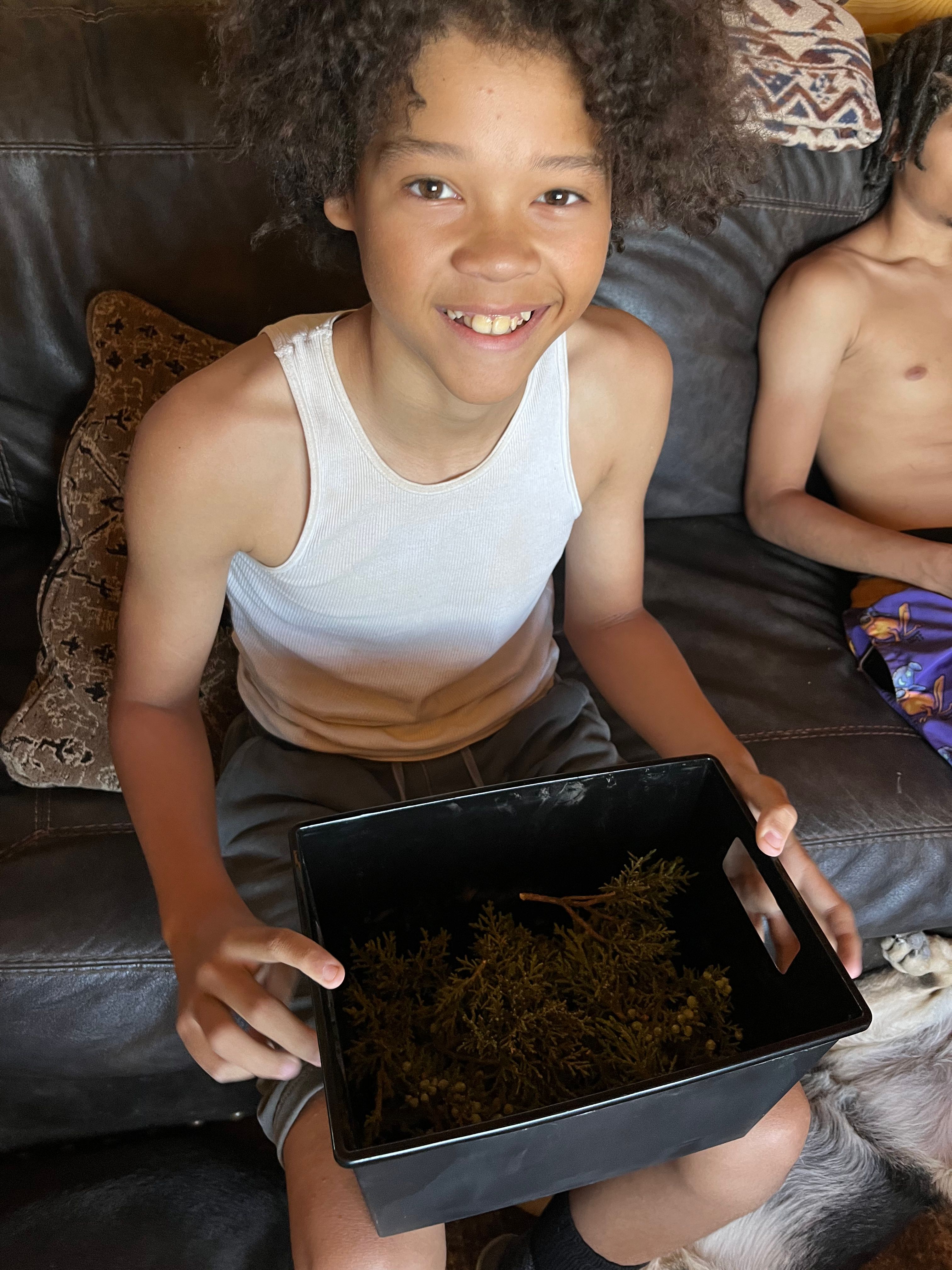 Ja'Lani Lopez holding his first harvest — one of the founders of the Young Legacy Entrepreneurs program