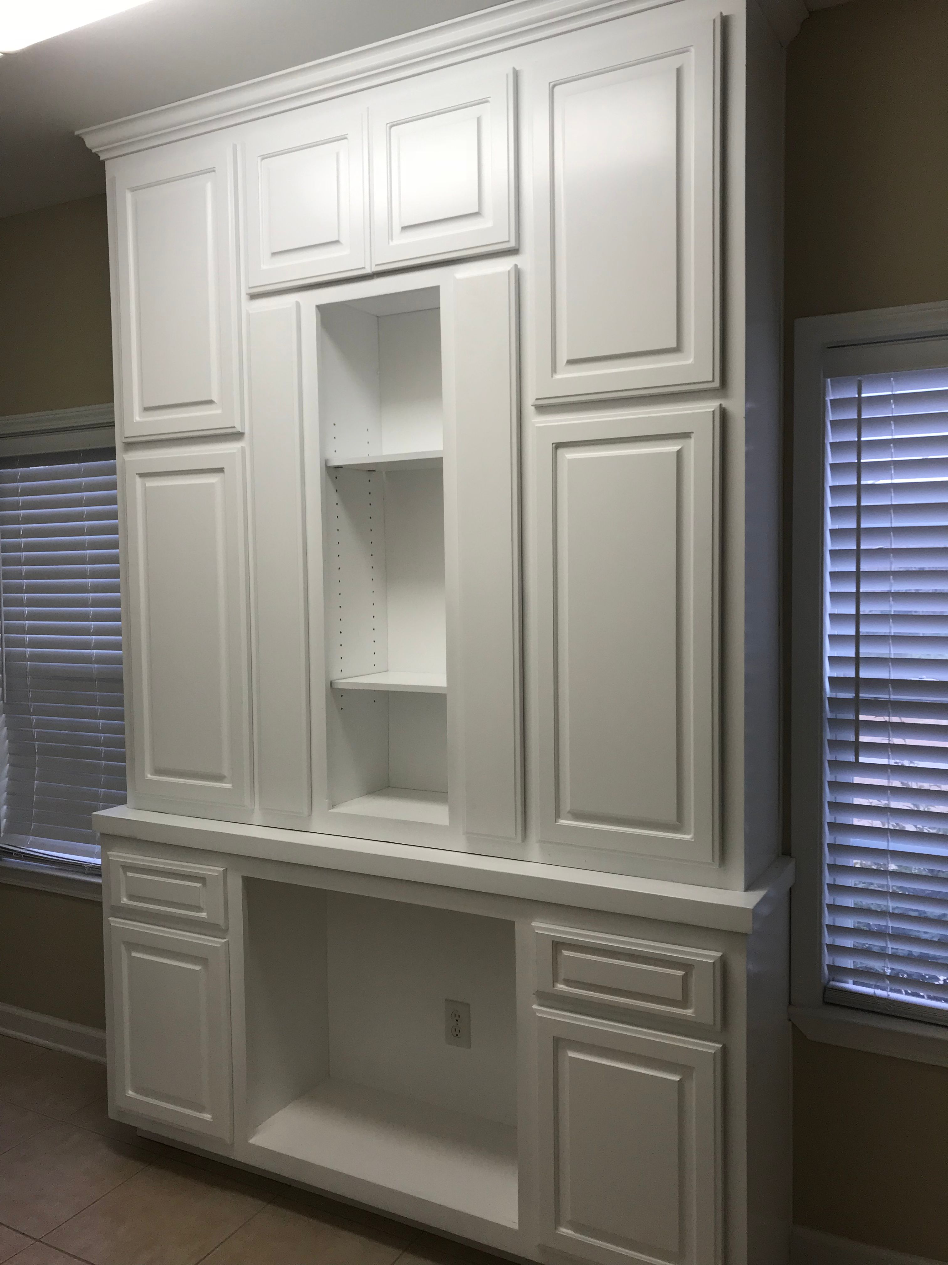 White built-in cabinet unit with shelving and paneled doors