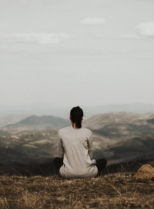 A woman overlooking a wide mountain landscape