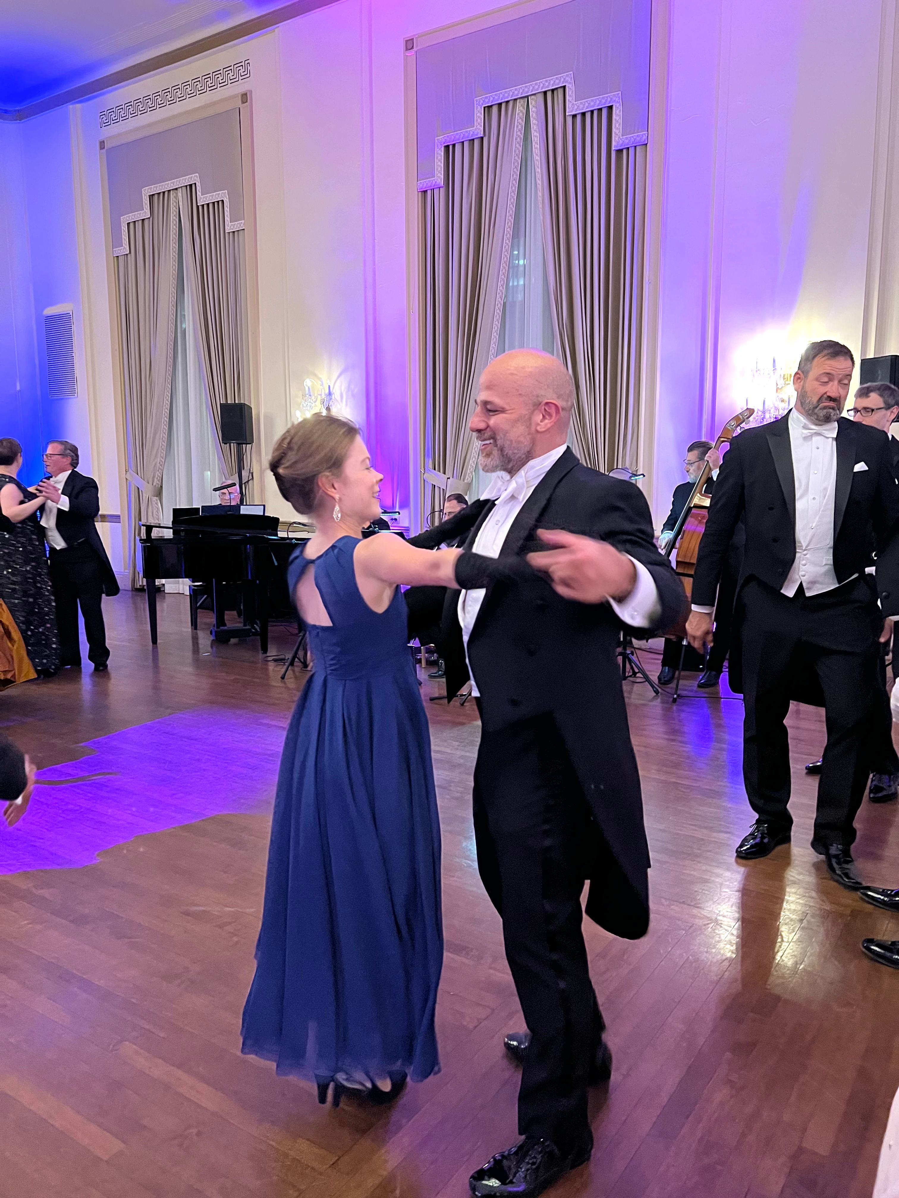 The Waltz Series β couples dancing in formal evening attire in an elegant ballroom with purple lighting, man in tuxedo and woman in blue gown