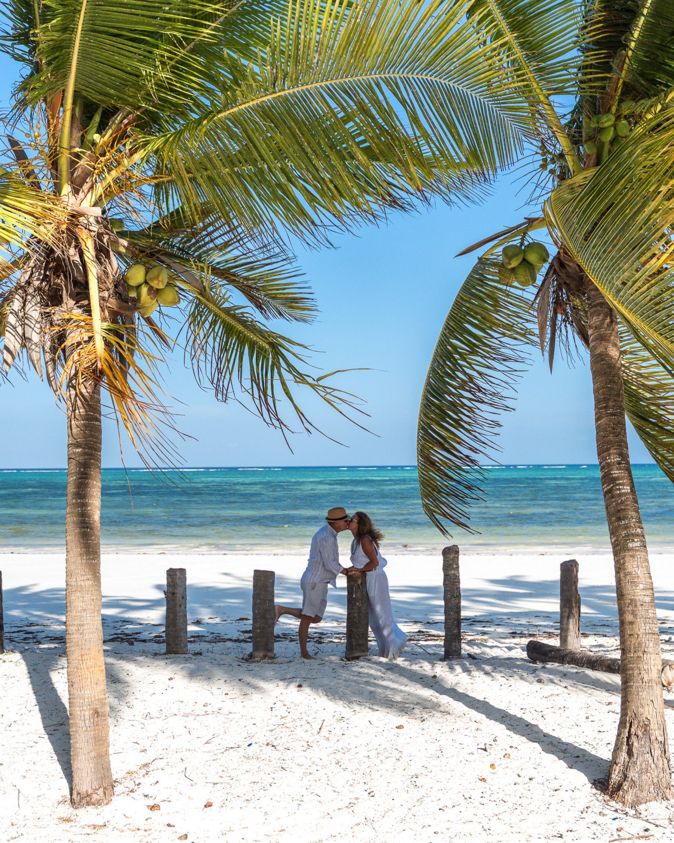 Couple under palm trees Zanzibar