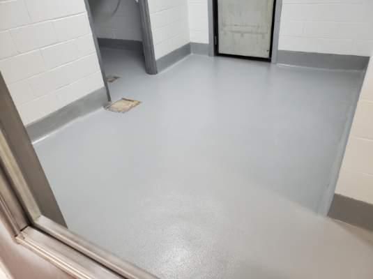 Seamless light gray epoxy floor with floor drains in food and beverage facility room