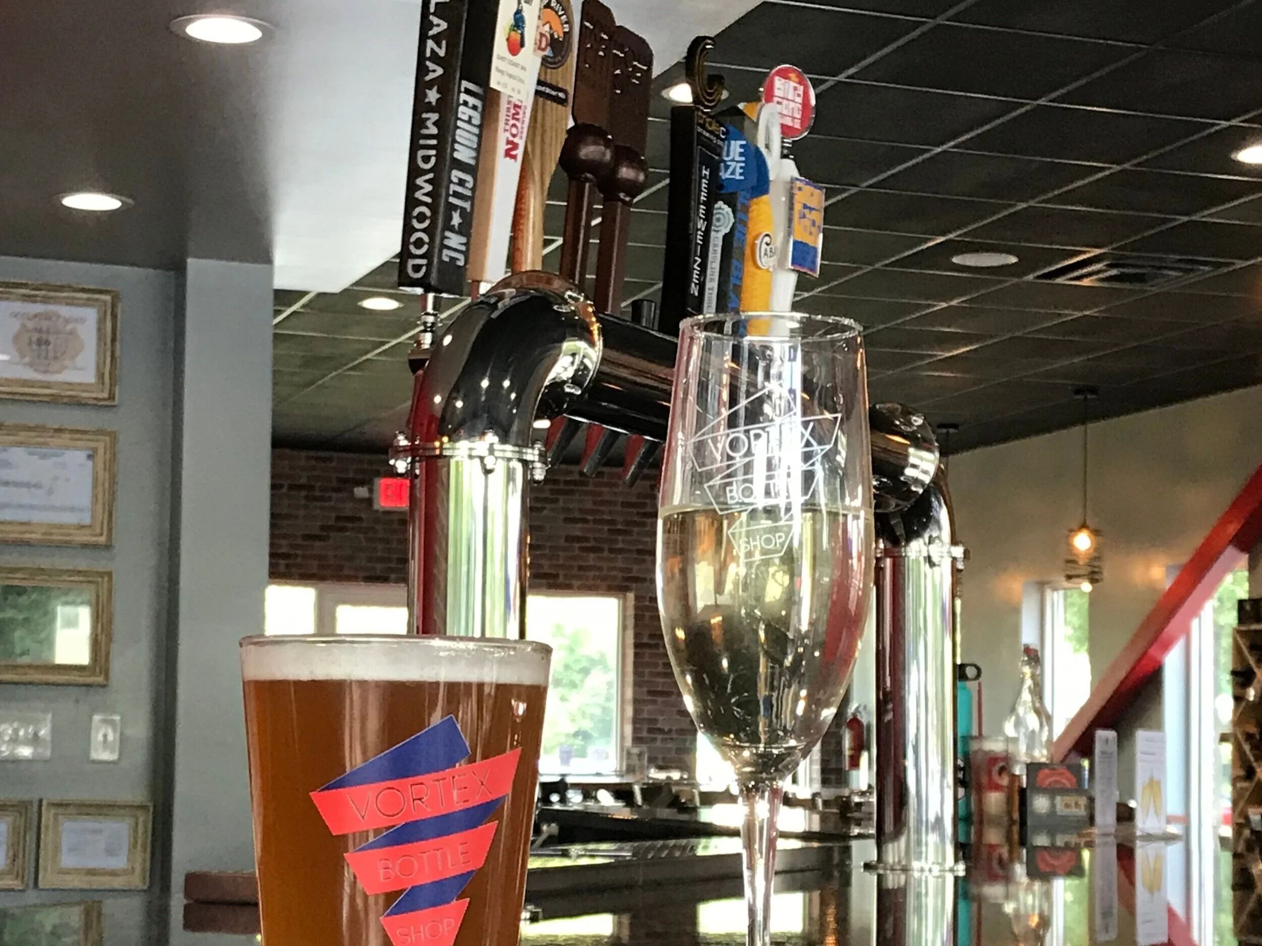 Vortex Bottle Shop branded pint glasses at the bar