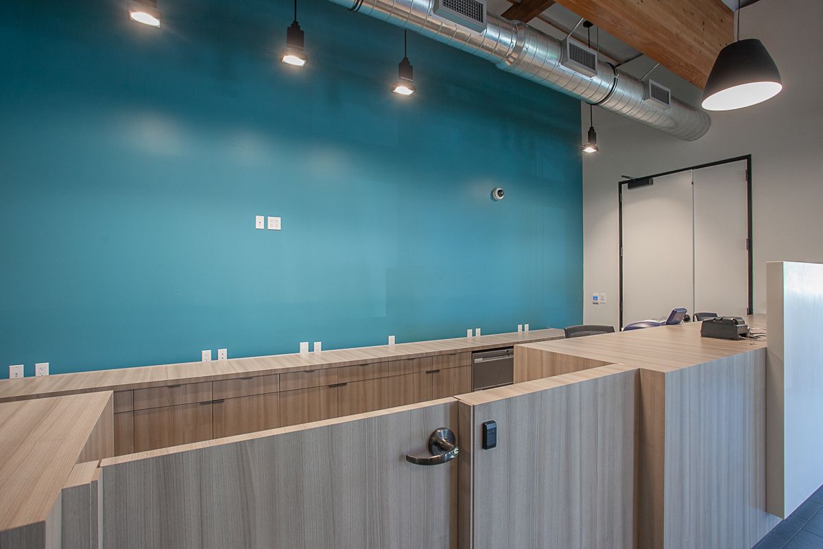 Modern commercial reception desk with custom millwork and accent wall in Oxnard CA office buildout