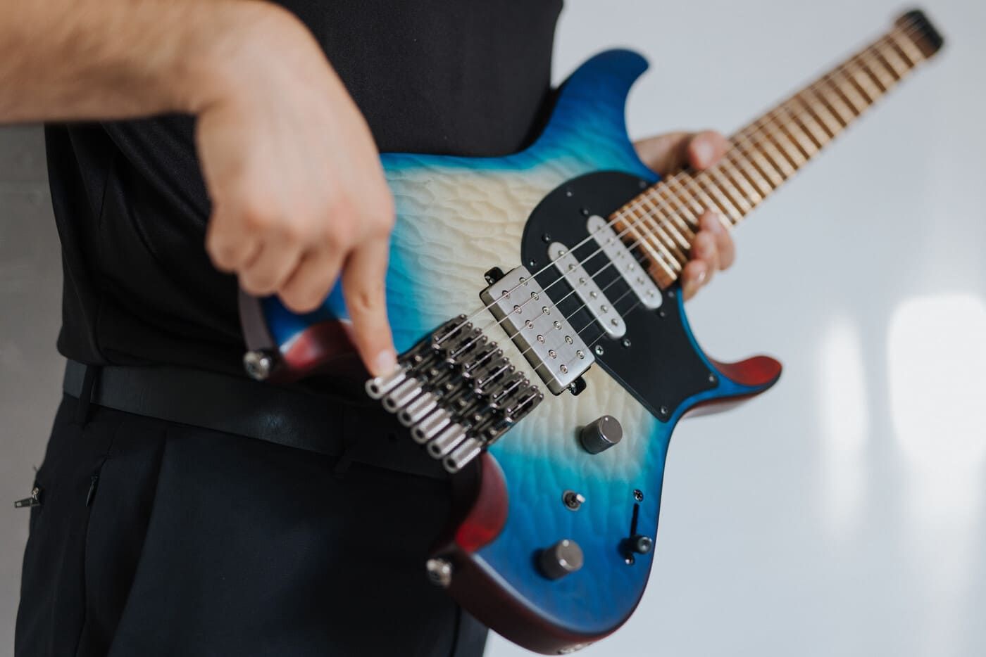 Tyler holding a blue-to-white gradient electric guitar