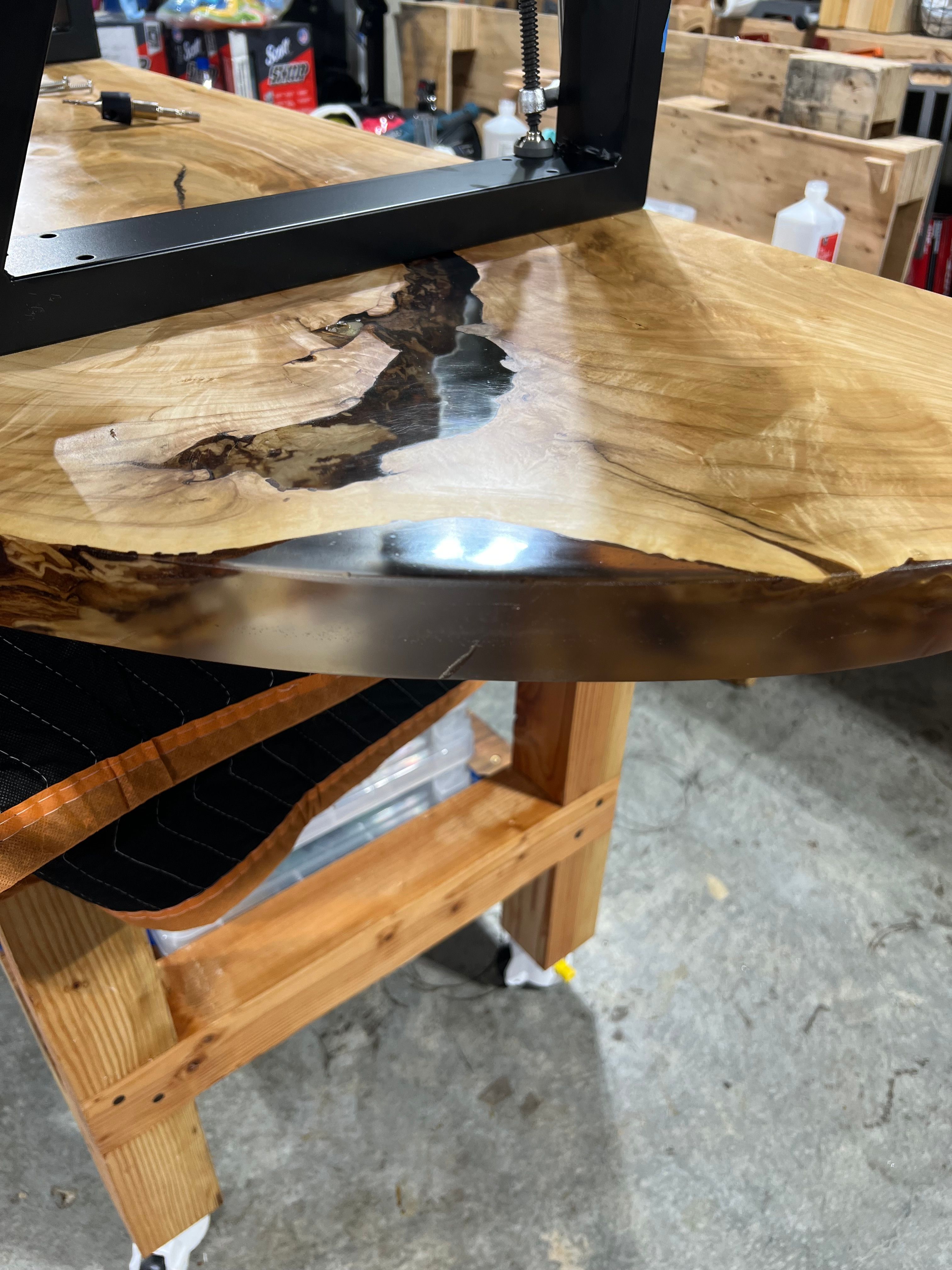 Live edge table with resin inlay in progress on workbench