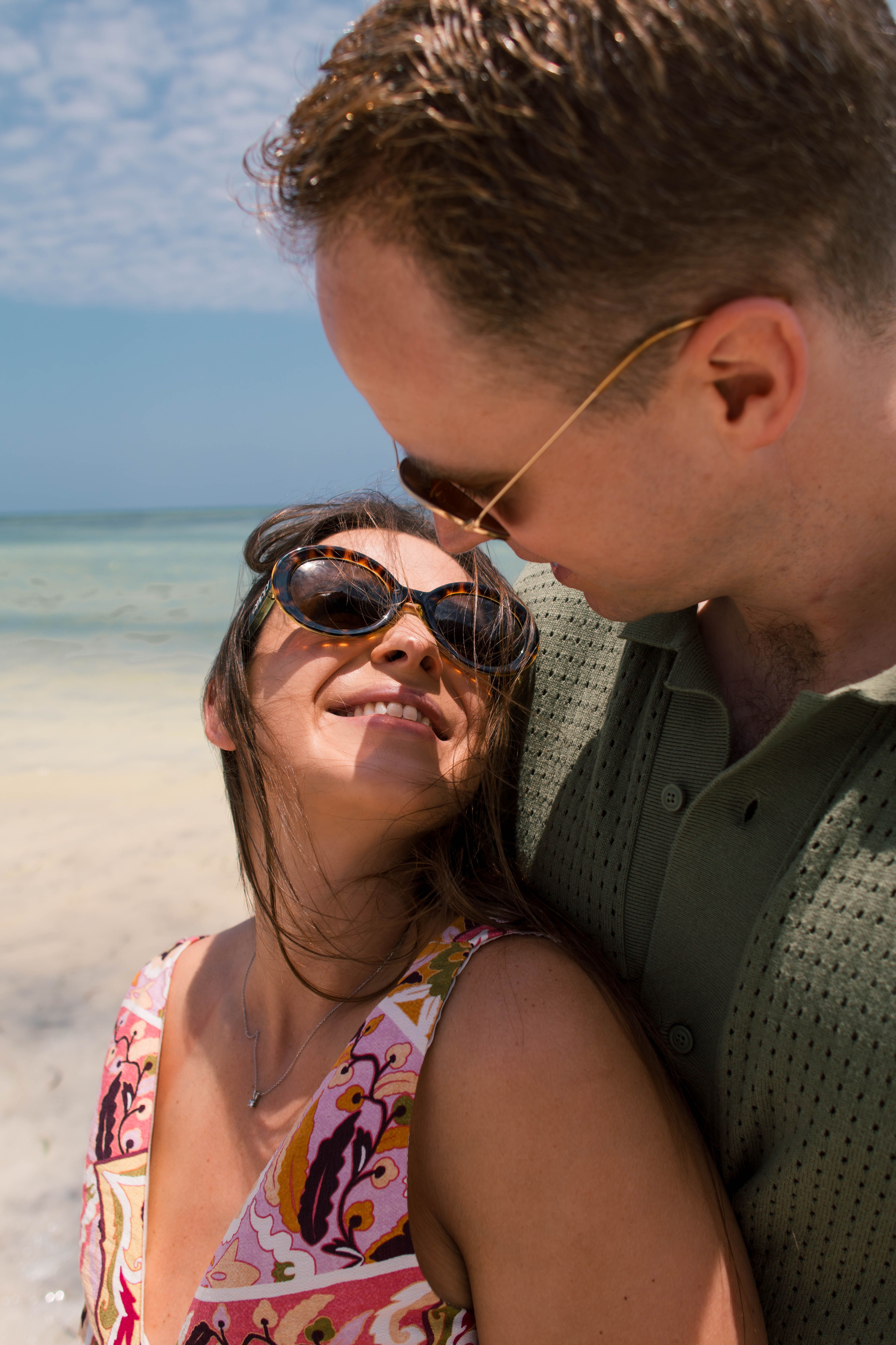 Couple laughing close-up with sunglasses on beach