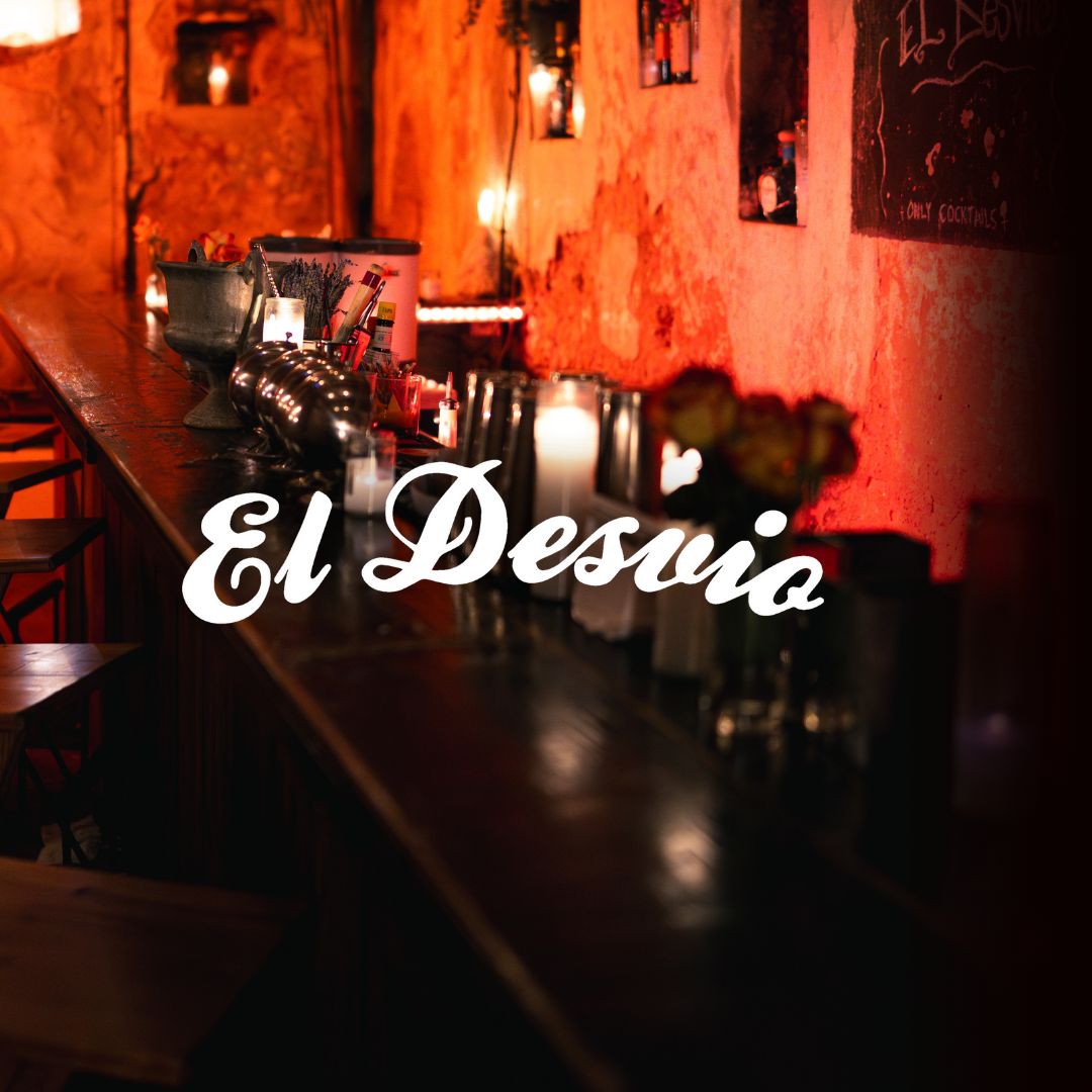 El Desvío — La Factoría's hidden 10-seat candlelit bar with candles, flowers, and warm amber lighting on a rustic wooden counter