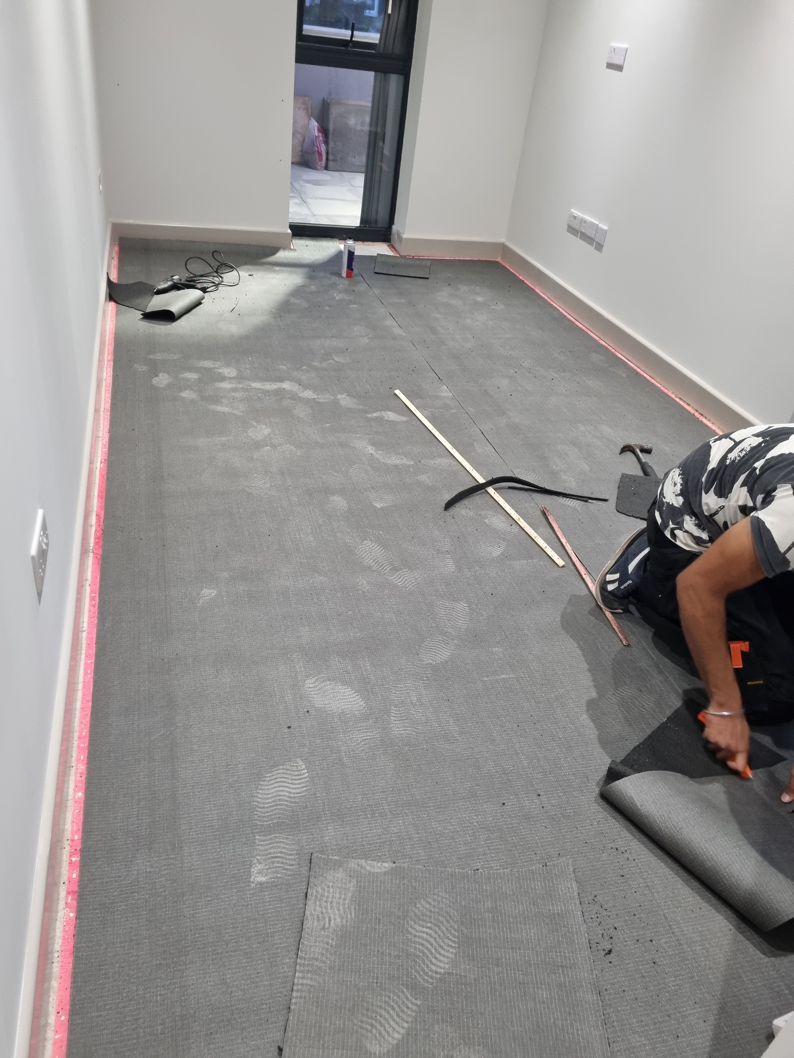 Technician preparing subfloor for carpet fitting