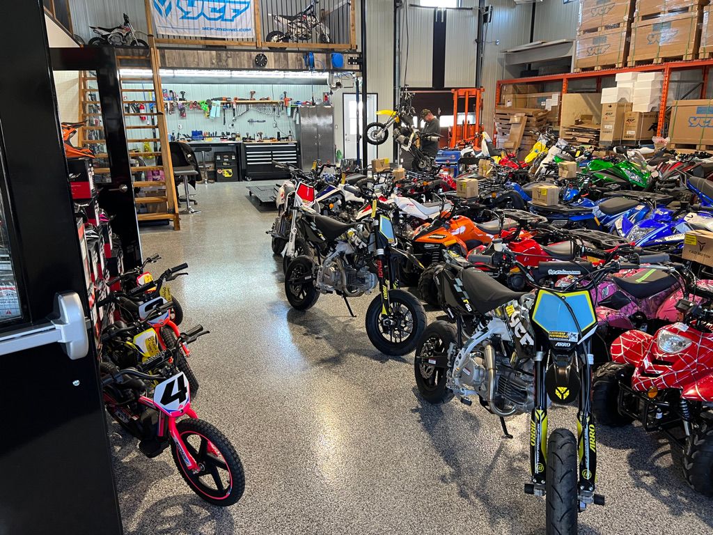 Powersports shop floor with polished concrete epoxy and motorbikes, dirt bikes and equipment throughout
