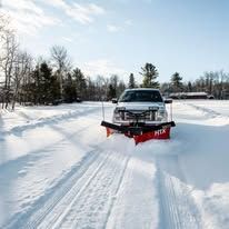 Snow plowing with truck and plow in winter