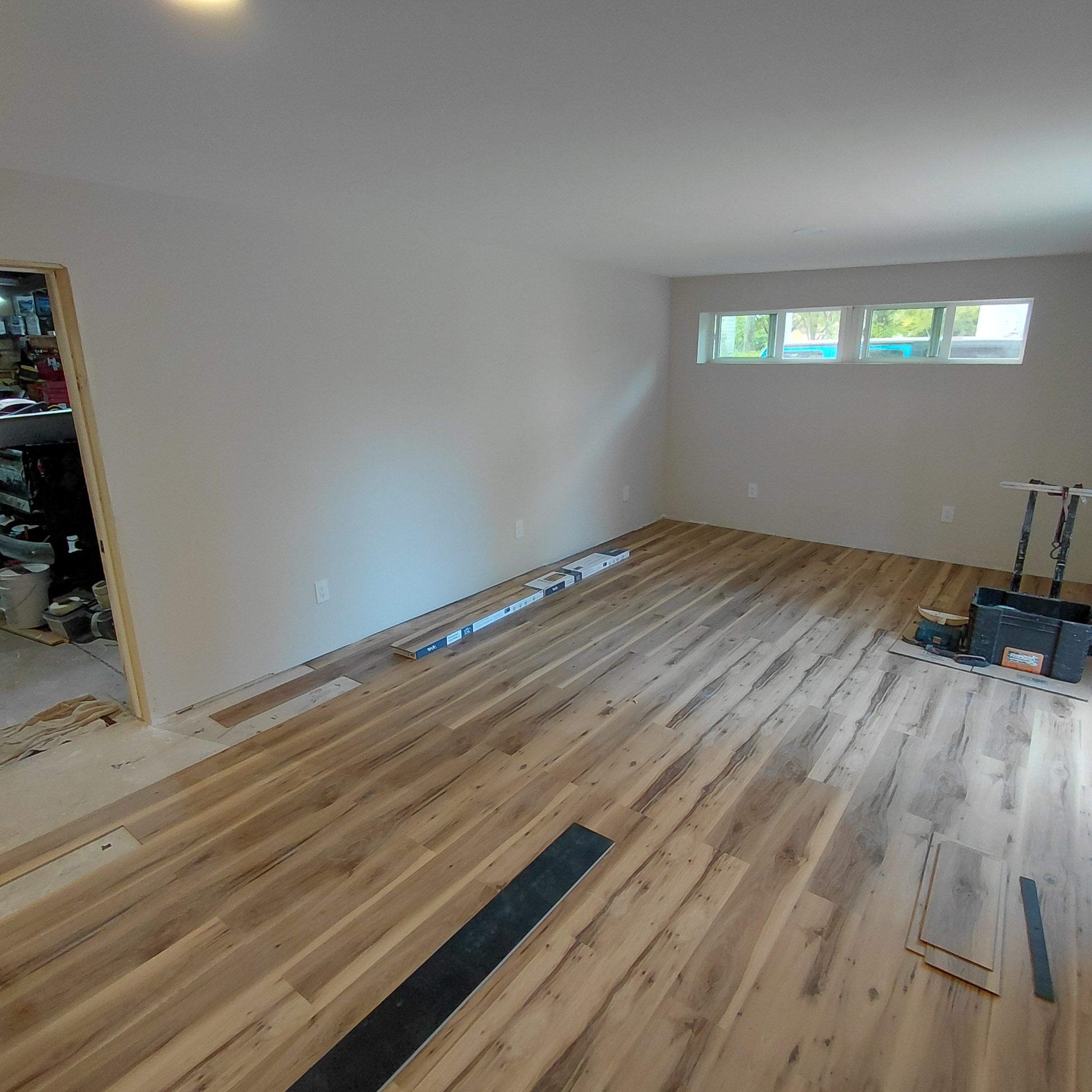 New flooring installed in an empty room with construction materials
