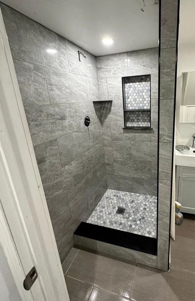 Shower with hexagonal floor tiles and niche