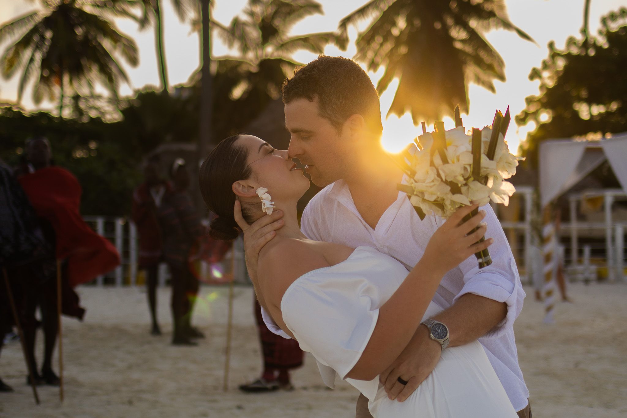 Couple embracing at sunset on Zanzibar beach with flowers