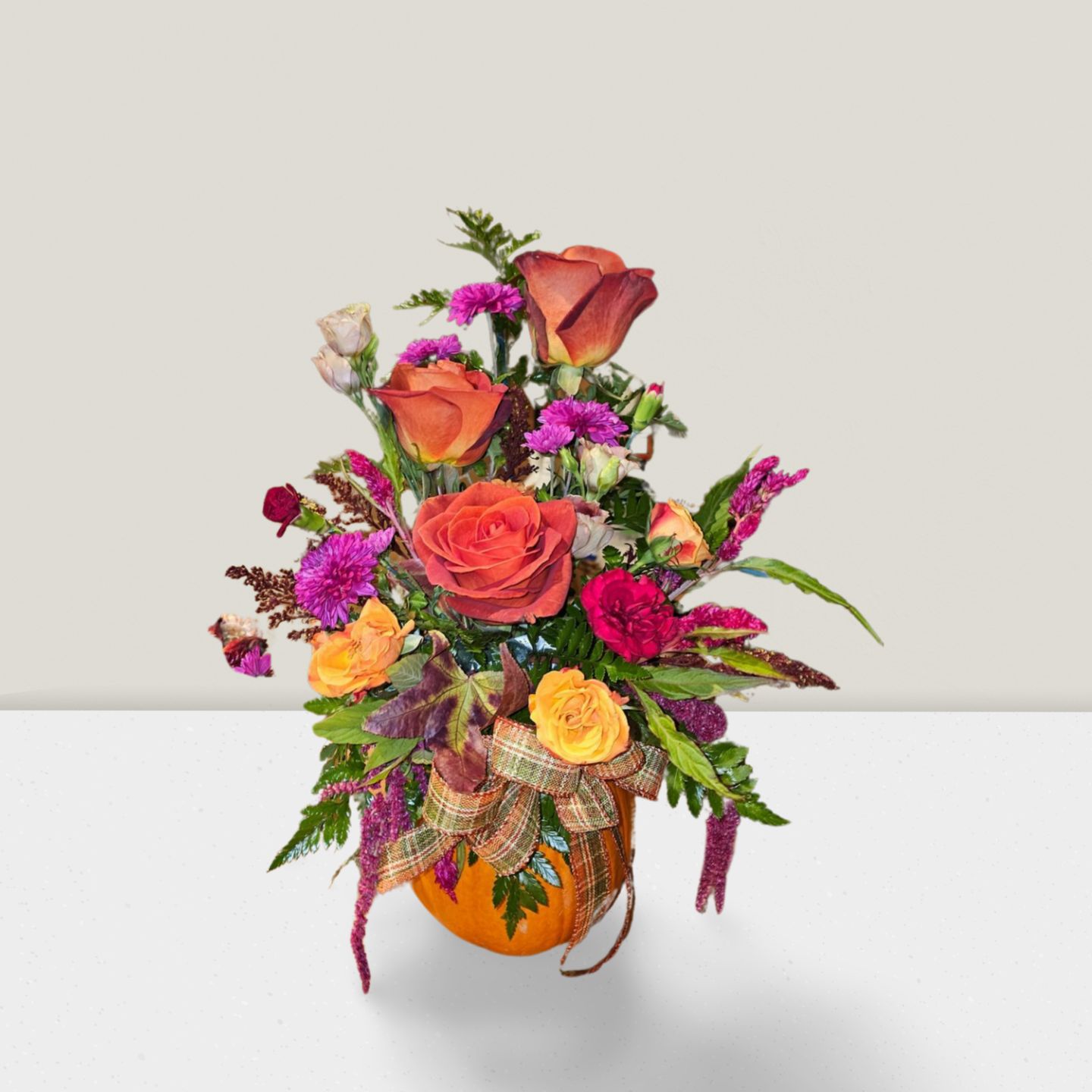 Fall pumpkin arrangement with orange roses and plaid ribbon