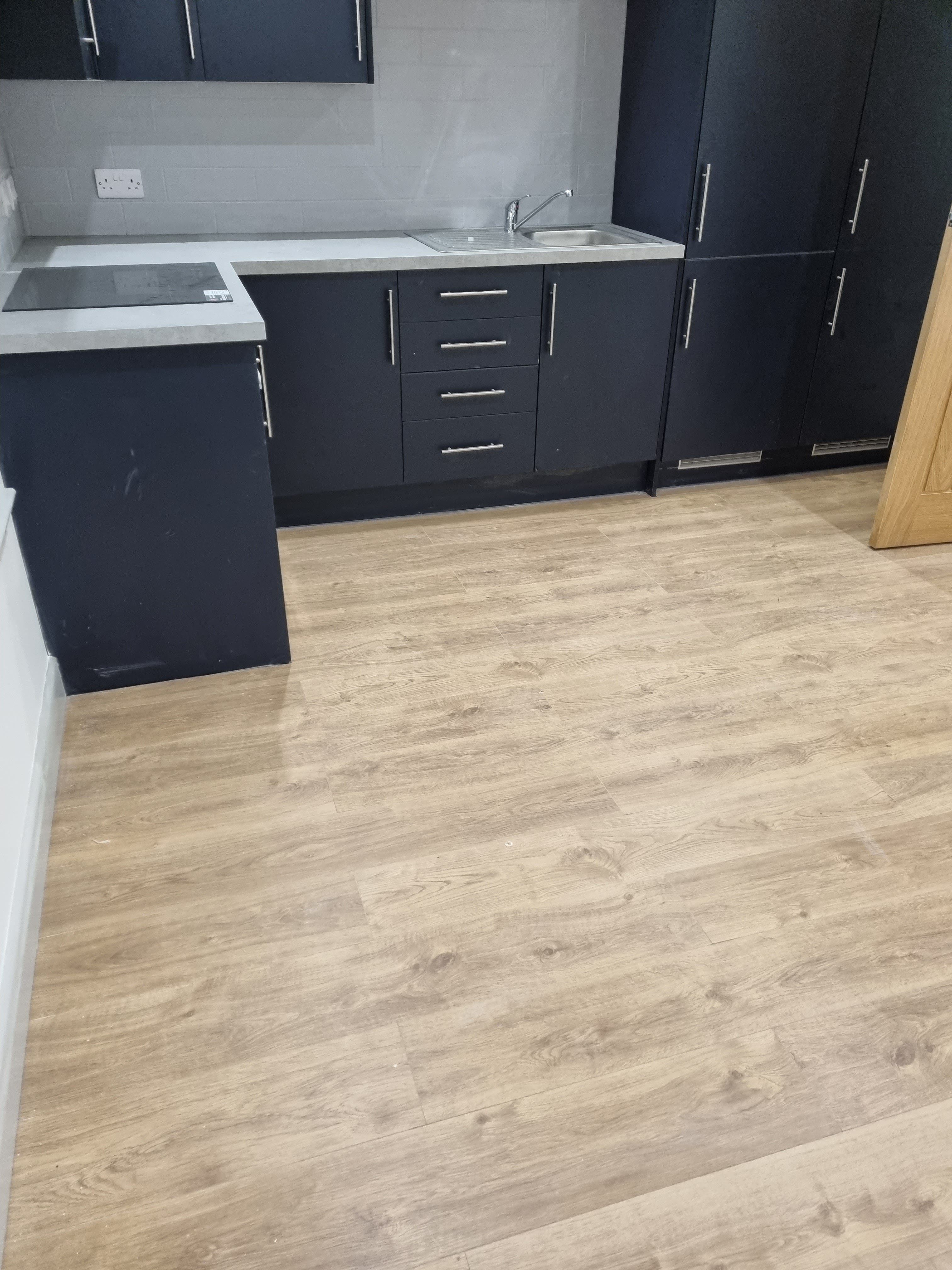 Modern kitchen with blue cabinets and wood-effect SPC flooring