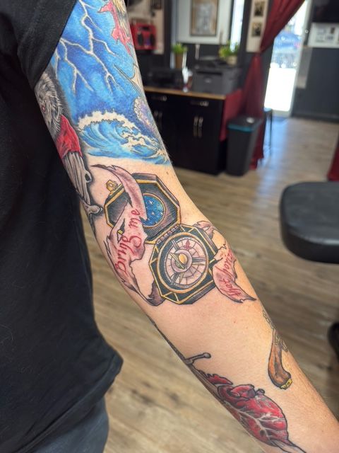 Color tattoo by Justin - compass with ribbon and ocean wave elements