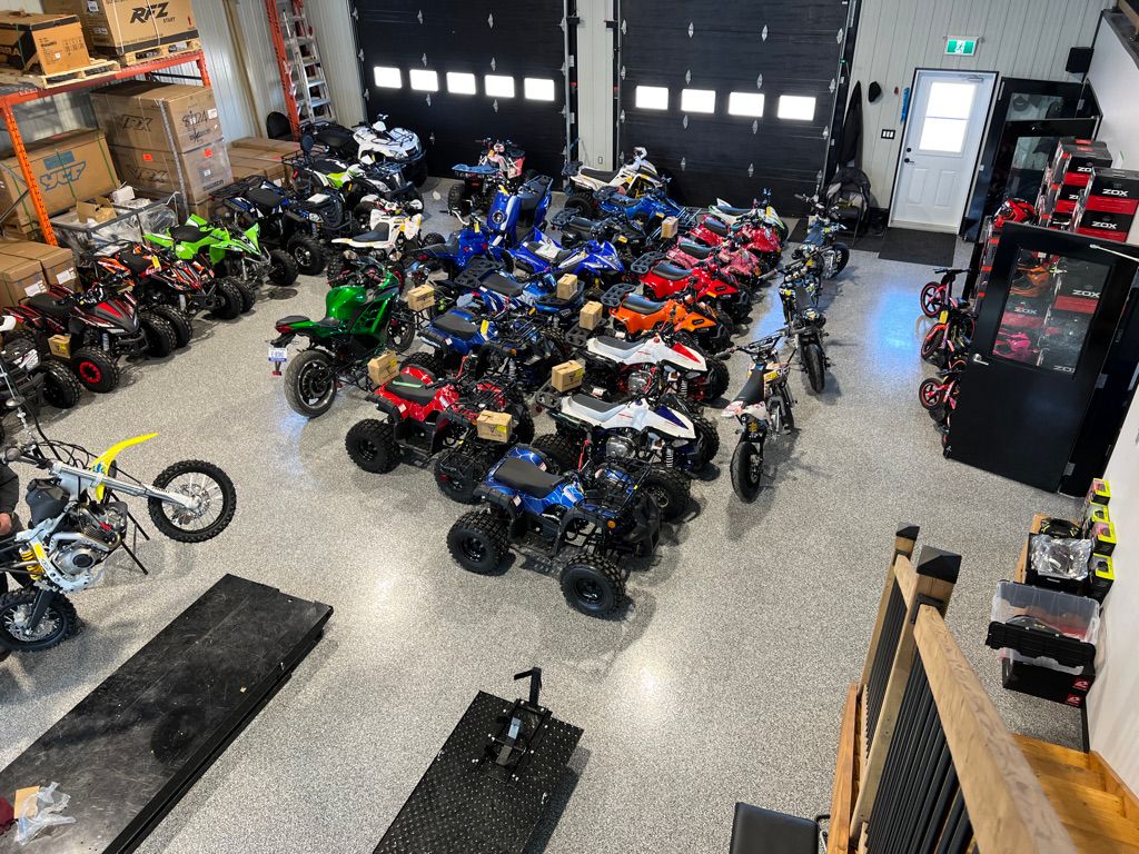 Powersports dealership showroom with speckled epoxy floor and rows of ATVs and motorbikes on display
