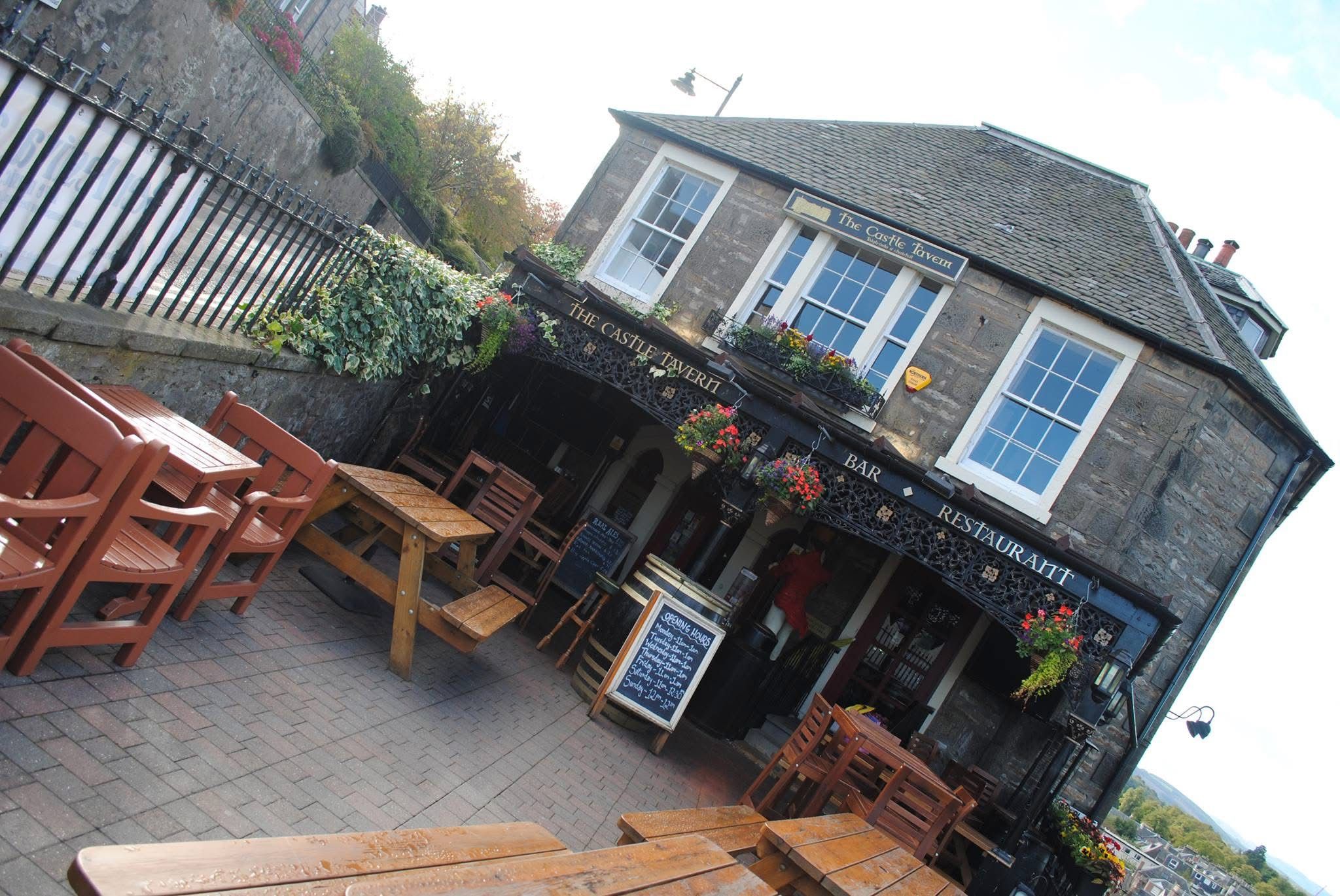The Castle Tavern exterior with outdoor seating and flower baskets