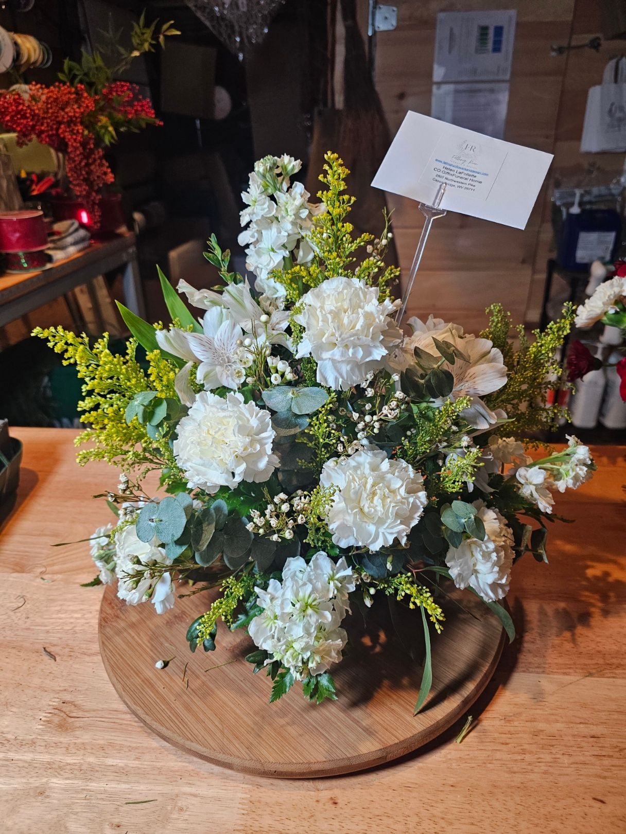 White sympathy arrangement with carnations and delicate greenery