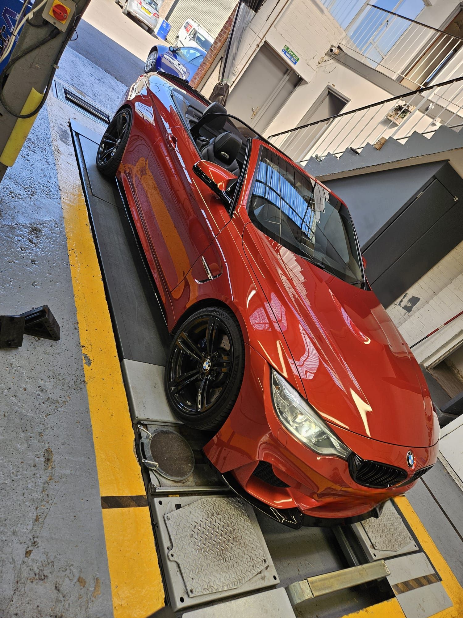 Red BMW convertible in workshop
