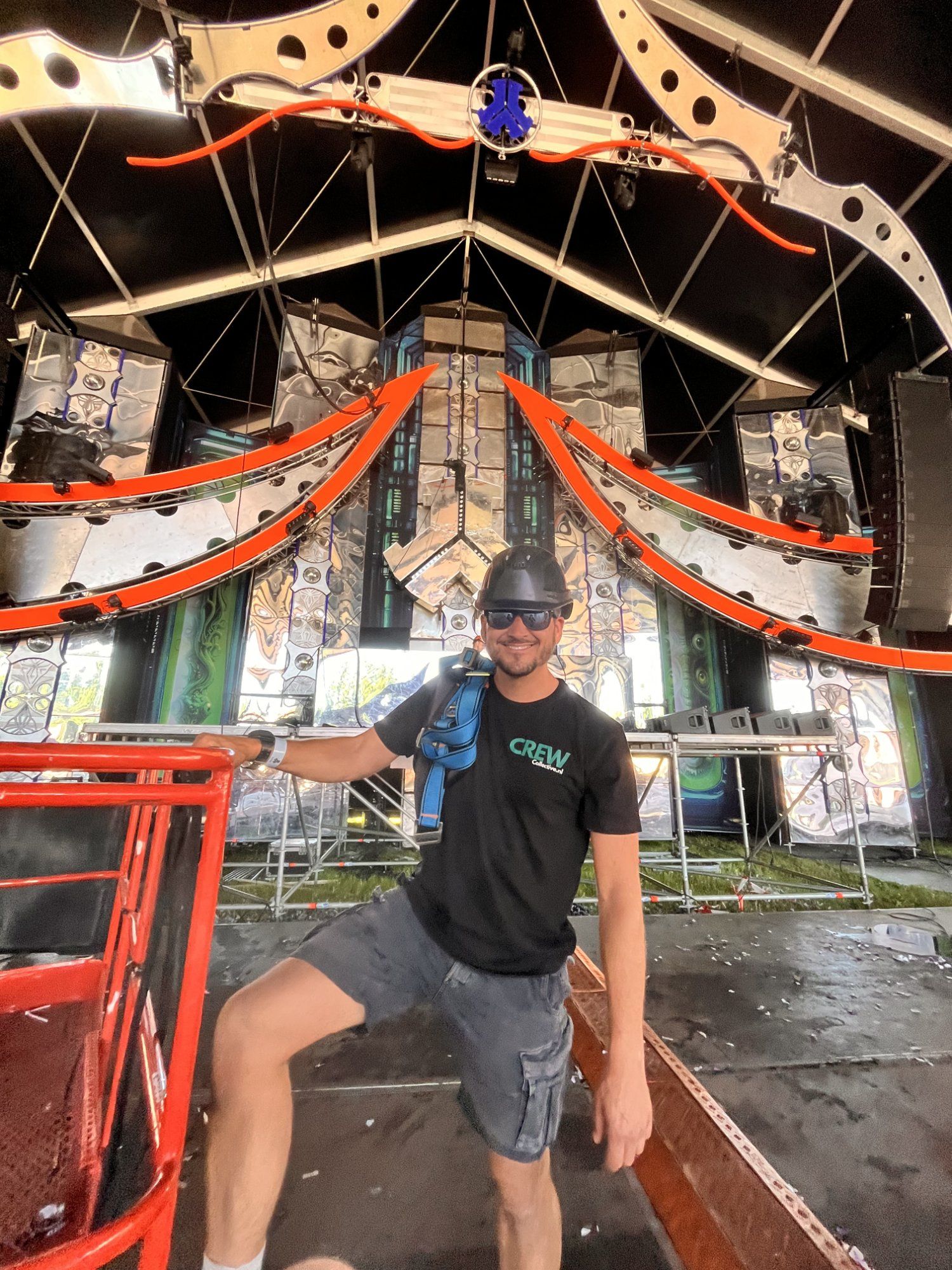 Stagehand staat op een podium tussen trussconstructies en lichtinstallaties tijdens opbouw