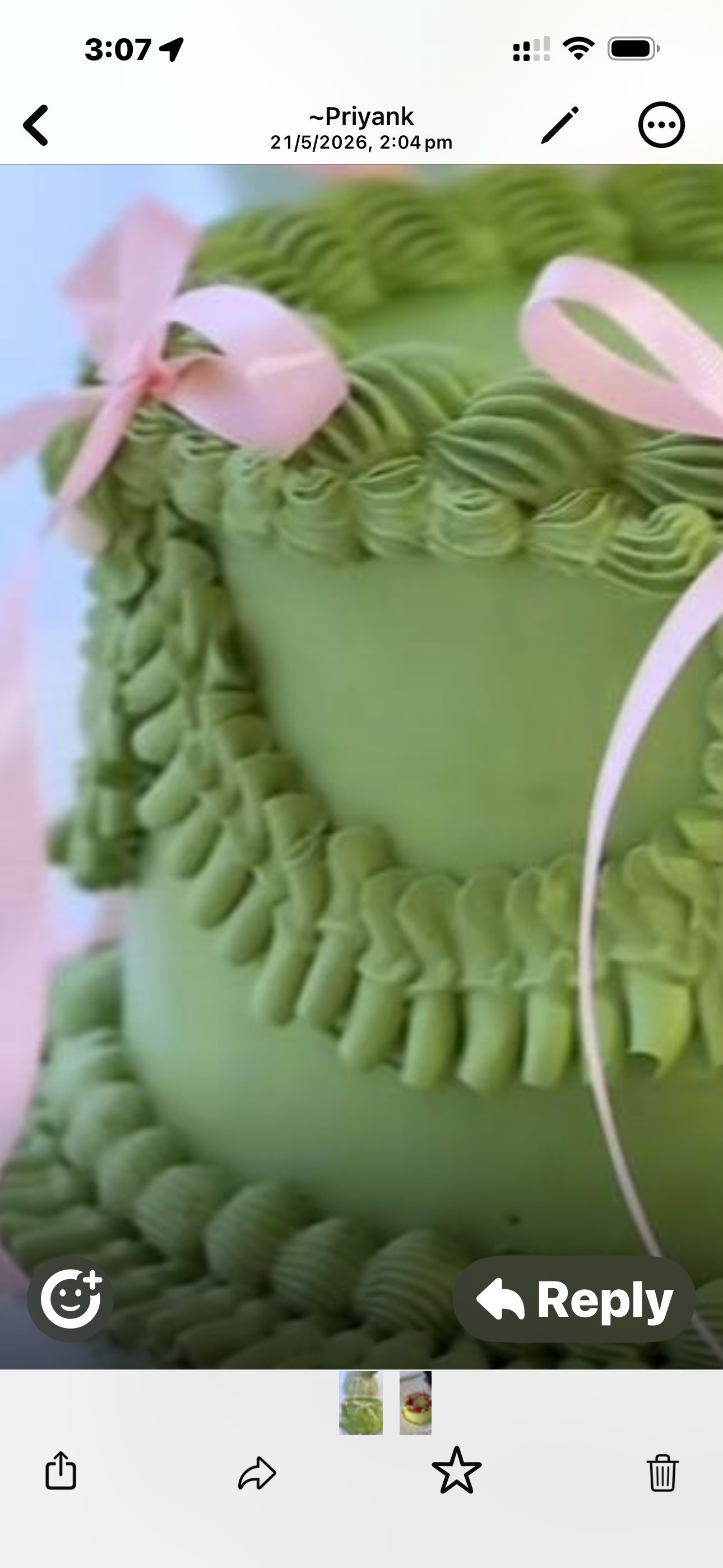 Close-up of sage green buttercream cake with pink ribbon bows