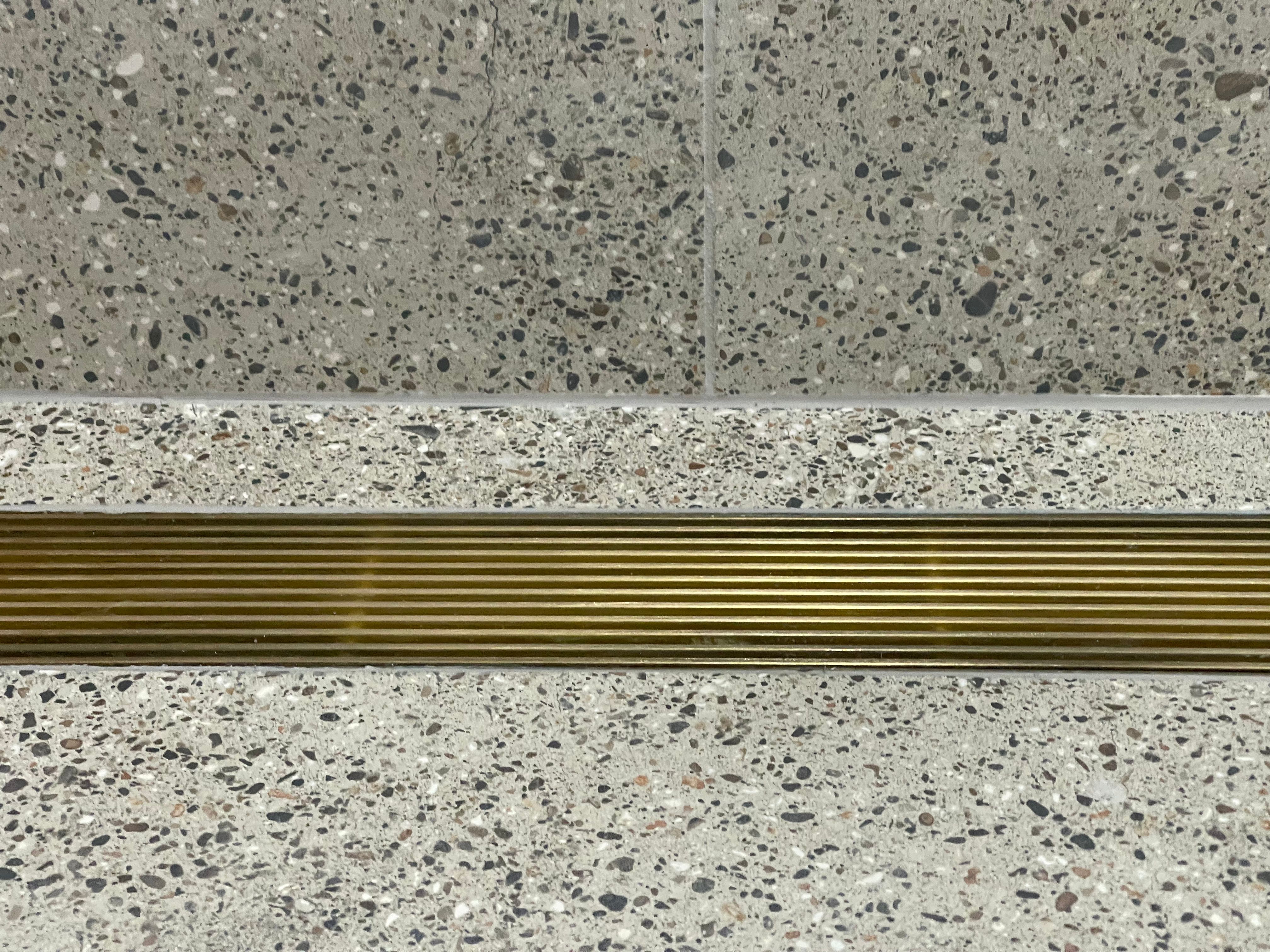 Gold brass grate in terrazzo floor