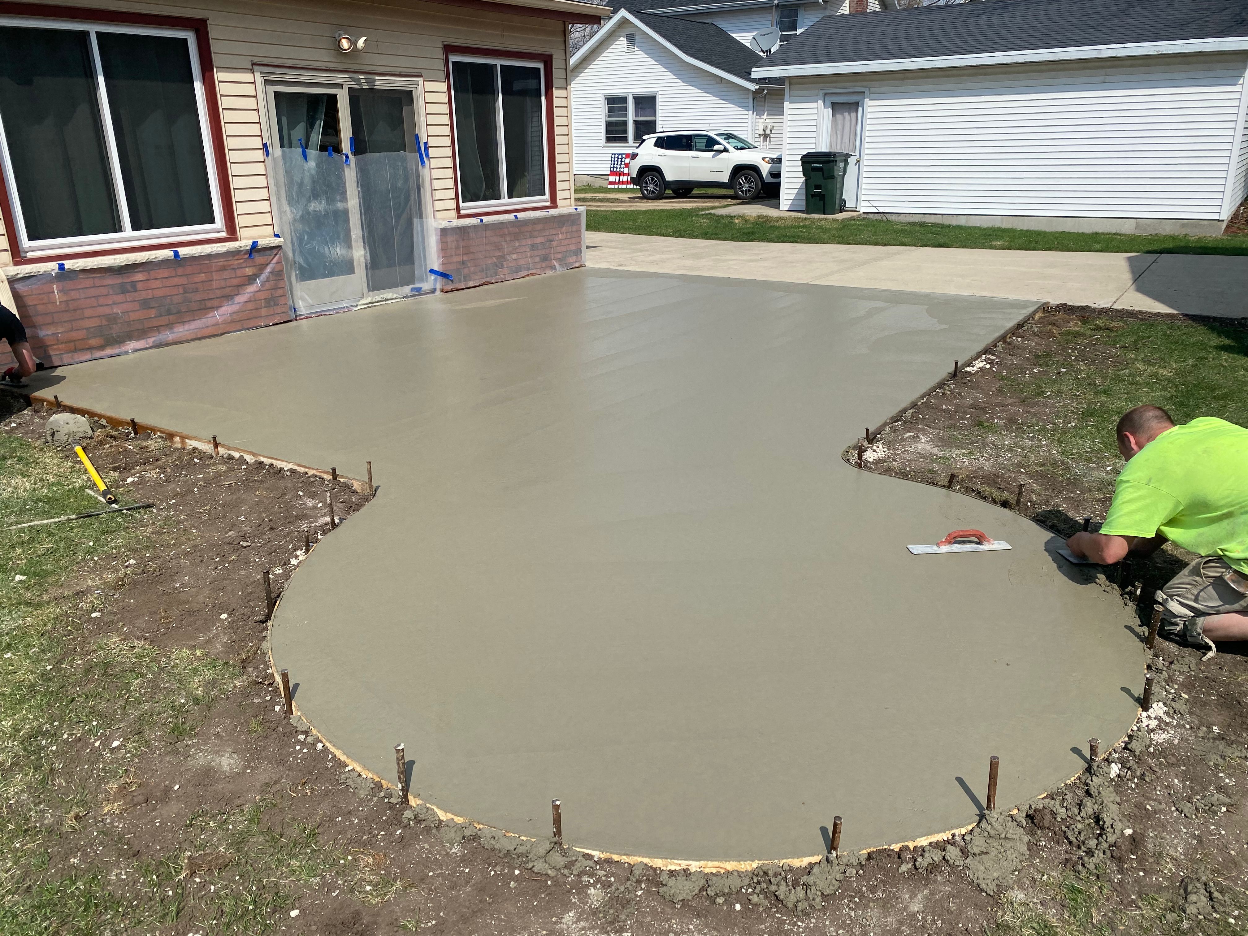 Empire Construction crew finishing a curved concrete patio