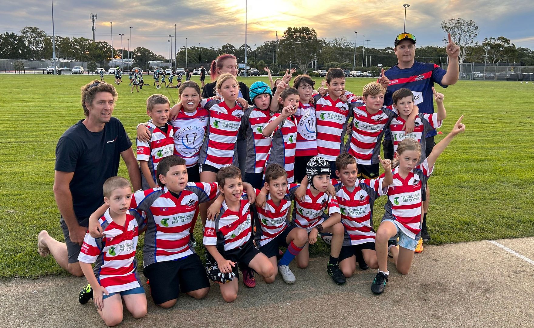Junior team with coaches at sunset