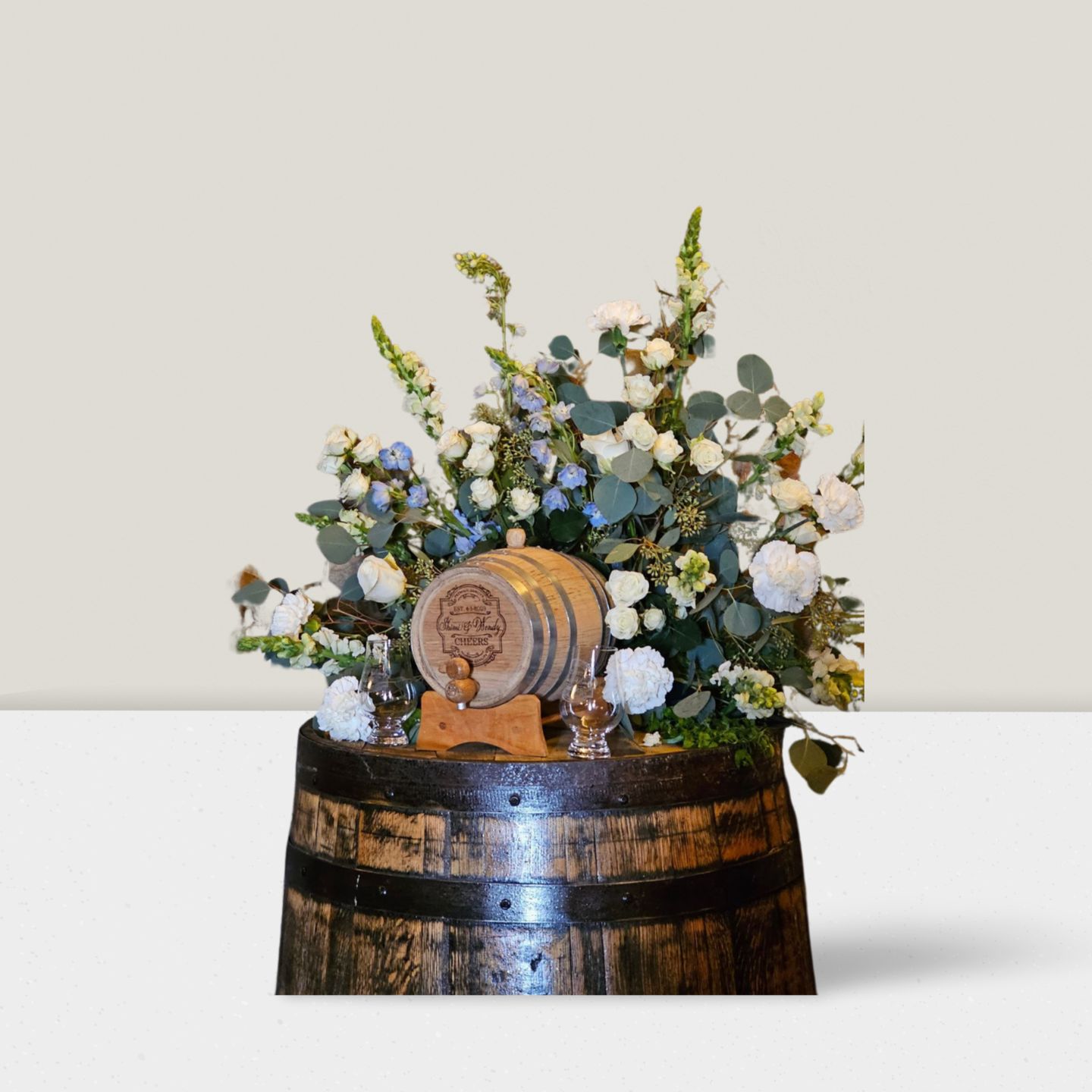 Styled bar detail with barrel, cask, and floral accents