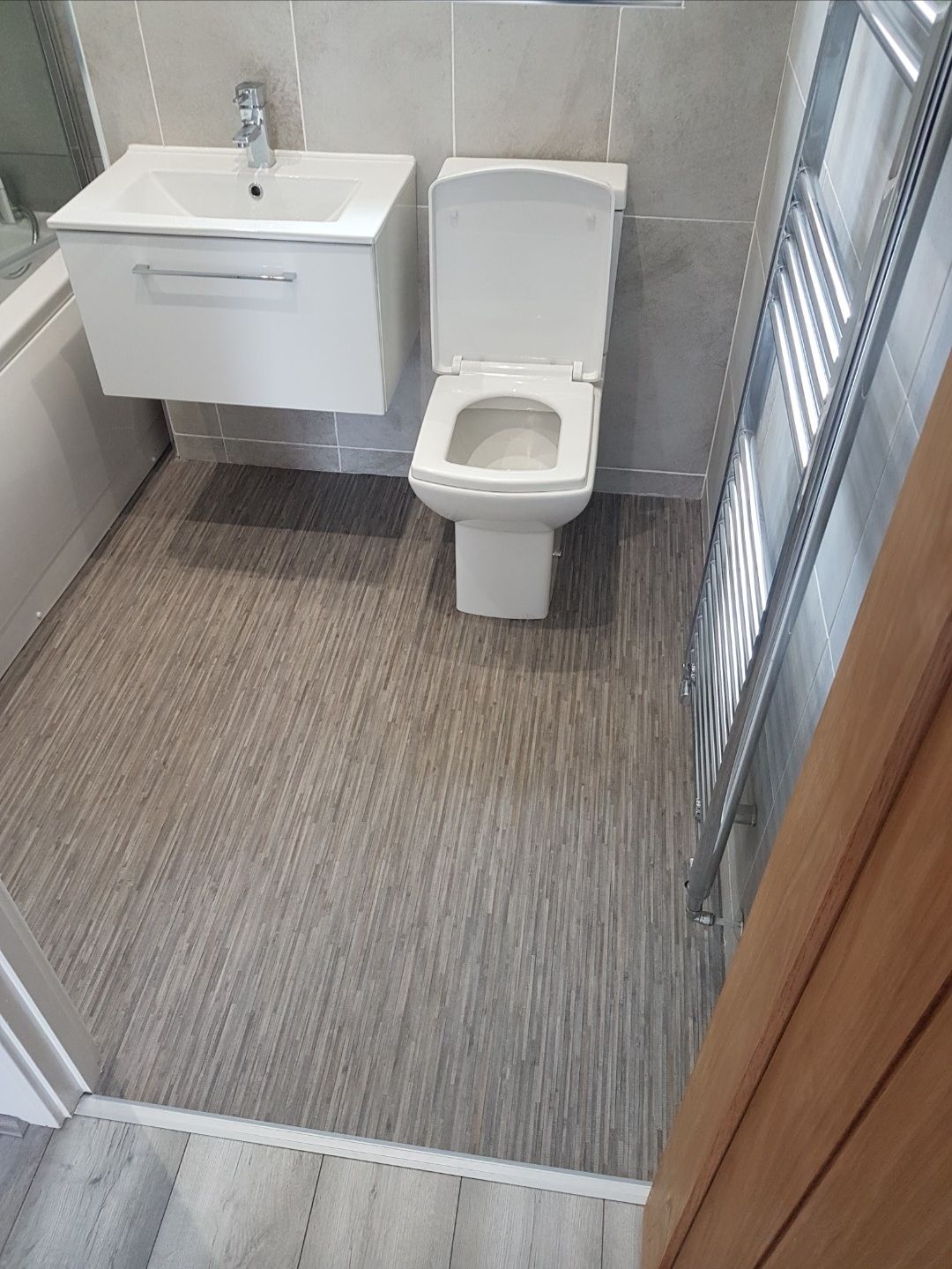Finished bathroom with stylish wood-effect vinyl flooring