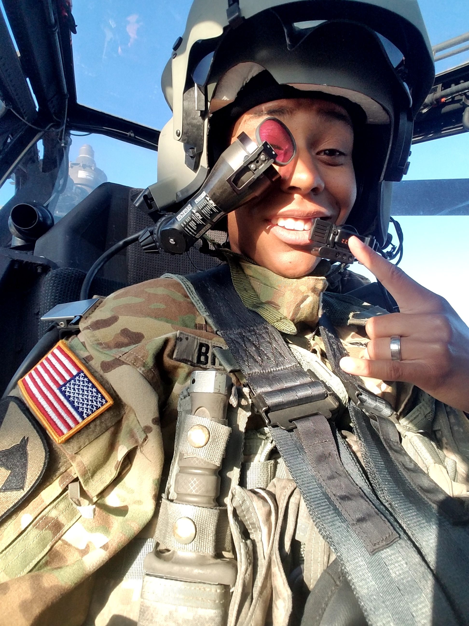 Tiara Brown in Apache helicopter cockpit in military flight gear
