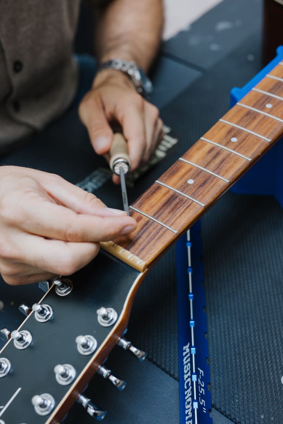 Close-up of Tyler filing and smoothing sharp fret ends