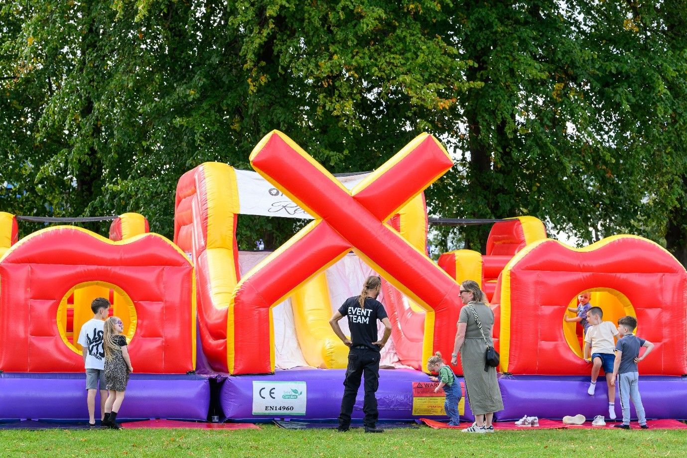 Children and families enjoying inflatable activities at a corporate family fun day by Event Collection