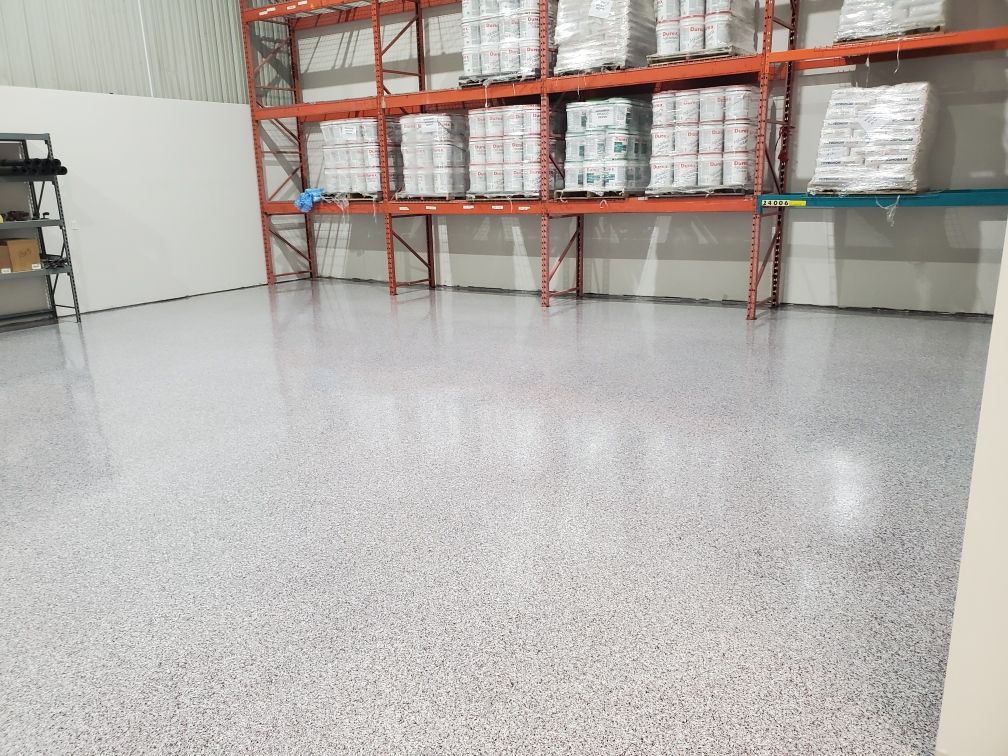 Distribution warehouse with polished speckled epoxy floor and organized shelving holding packaged product