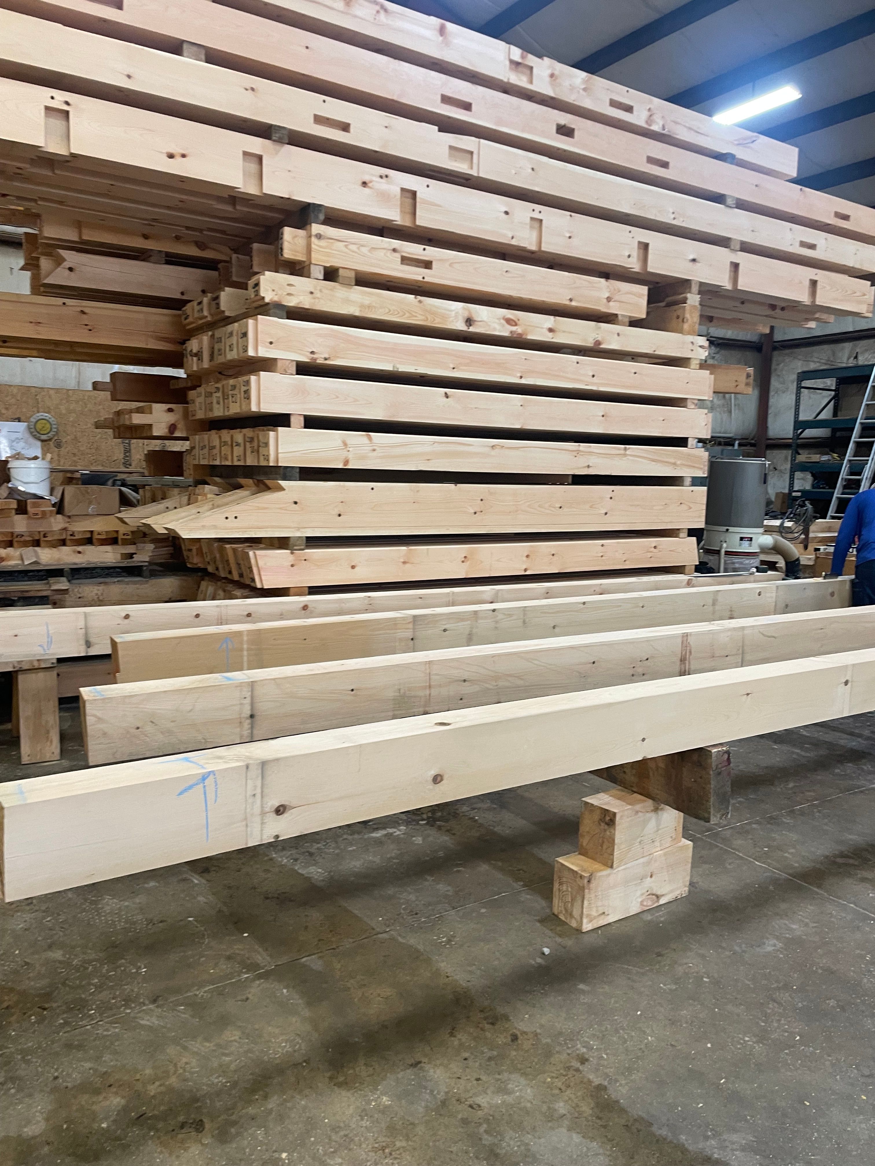 Stacks of wood beams in warehouse ready for projects