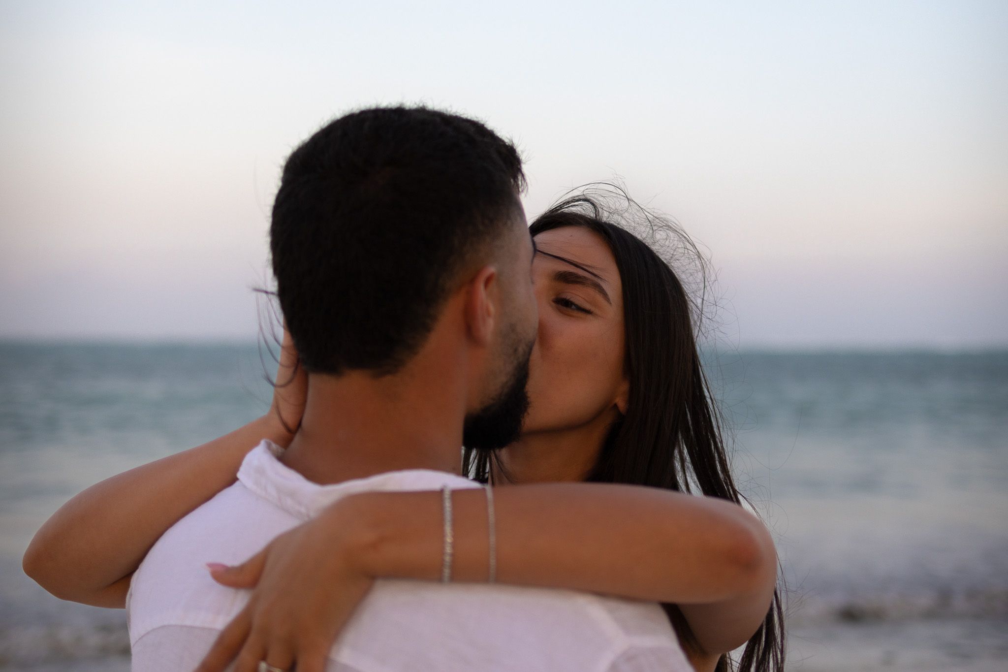 Couple embracing and kissing on the beach